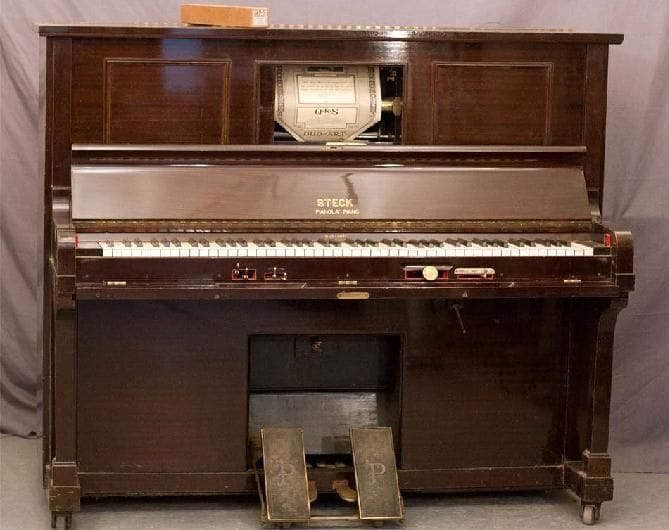 PIANOLA STECK Cadre en fonte recouverte Cordes croisées. En acajou foncé. Hauteur 128 cm Mécanisme à rouleaux pneumatique. Fonctionne Avec quelques rouleaux divers. Instrument intéressant pouvant être joué normalement, et très divertissant avec ses rouleaux d'un autre temps