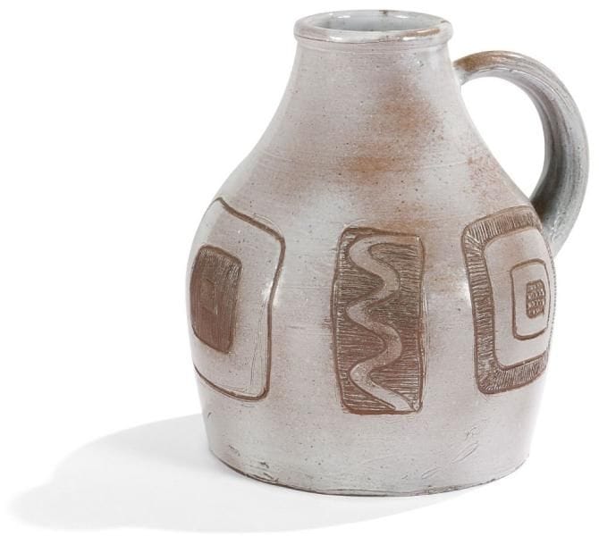 Jeanne & Norbert PIERLOT (1917-1988) & (1919-1979) - Château de RATILLY
Rare pichet en grès émaillé gris pâle.  Décor tournant de motifs abstraits gravés laissant apparaître le brun de la terre.  Signé PIERLOT sous la base et à la « chouette » en bas de la panse.  Hauteur : 26 cm