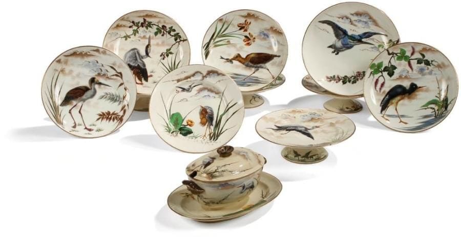 KELLER & GUERIN Lunéville
Oiseaux exotiques et aquatiques. Rare ensemble de dix coupes sur pied et d'une saucière en faïence fine porcelaineuse dite porcelaine opaque.  Les décors, tous différents et réalisés dans le goût du Japon, sont exécutés à l'émail et rehaussés de dorure, ils se poursuivent au revers des pièces.  Circa 1880.  Toutes les pièces sont signées du monogramme K.G. et parfois de celui du décorateur.  Bibliographie : « La faïencerie de Lunéville 1786 - 1923, les Keller & Guérin » par Annabelle Héry. Éditions Messene 1998. Modèles issus du même service reproduits page 71.