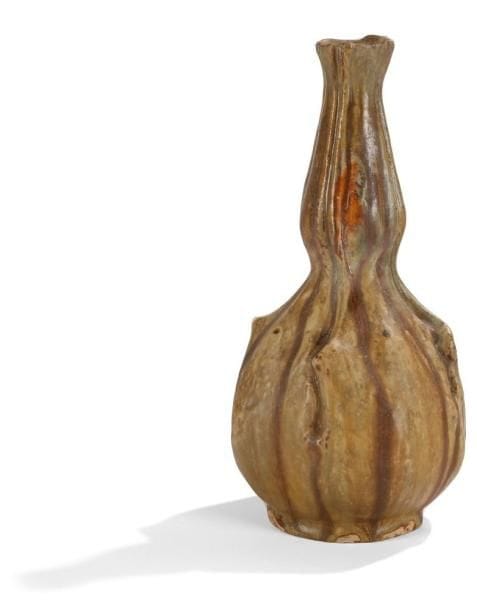 Nils de BARCK (1863-1930)
Haut vase naturaliste mouvementé en forme de coloquinte reposant sur talon.  Épreuve en grès émaillé brun et beige. . Un petit point de contact de four sur la panse, quelques retraits d'émail d'origine en pourtour du talon.  Signature manuscrite Nils de BARCK incisée sous la base et porte des mentions (illisibles) également gravées.  Hauteur : 31,5 cm