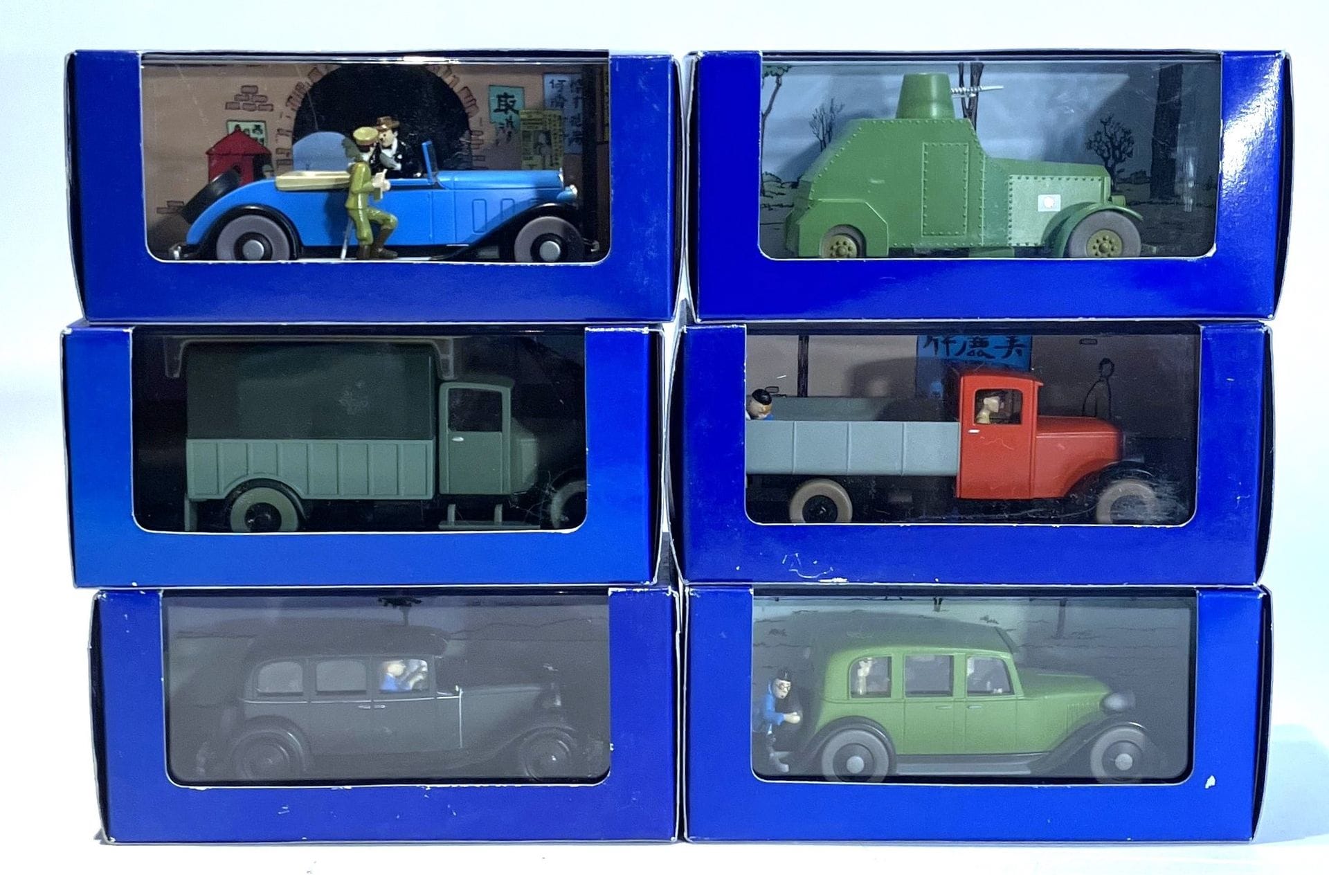 LE LOTUS BLEU – EN VOITURE TINTIN 
Lot de 6 modèles réduits. Éditions Atlas Hergé/Moulinsart, années 2000, dans leur boîte d’origine : 
- La limousine en route vers Nankin, Chrysler six, 1931, réf. 2118038,
- L’automitrailleuse blindée, Sumida ARM, années 20-30, réf. 2118037,
- La limousine, modèle d’inspiration divers, années 30, réf. 2118009,
- La décapotable, réf. 2118068,
- Le camion d’opium, années 30, réf. 2118-053,
- Le camion rouge, Miesse, 1933, réf. 2118036.