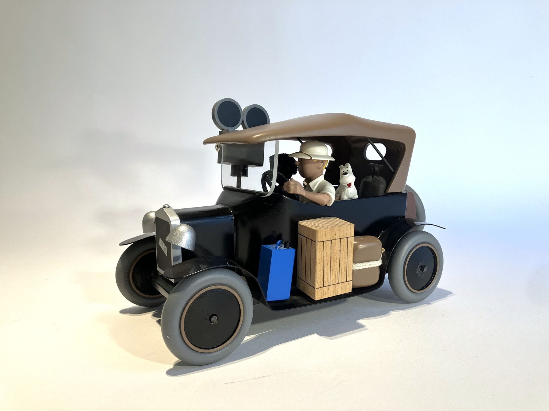 TINTIN AU CONGO 
Tintin en Ford T avec Coco et Milou
Groupe en résine, bois et métal polychrome. Éditions Moulinsart (étiquette sous la voiture). Réalisé en 1998. Dans une boîte thermoformée. L. 27 cm.