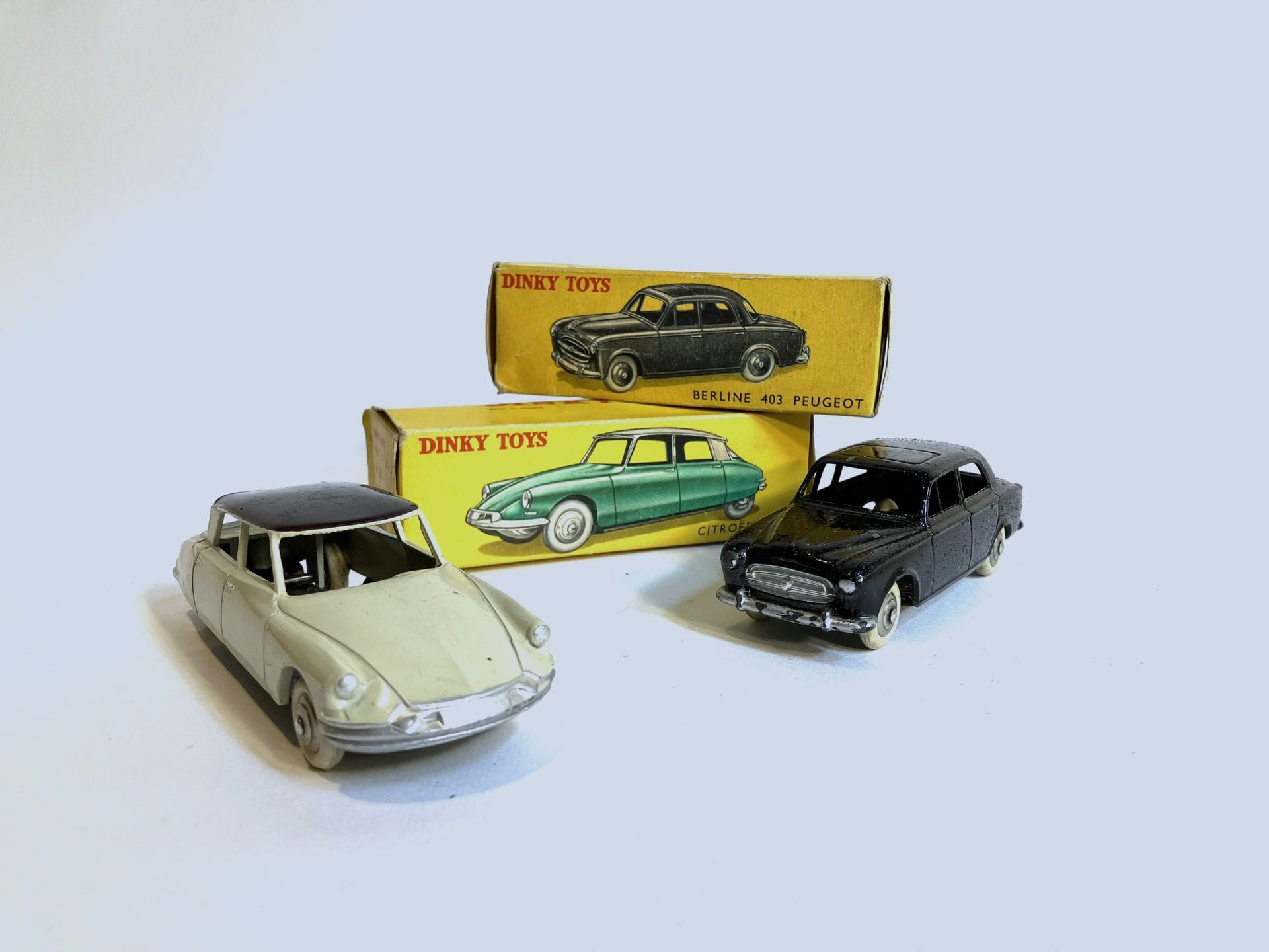 DINKY TOYS - Lot de 2 voitures :
- Berline 403 Peugeot, noire, ref. 24B, boîte. (Relaquée, usures).
- Citroën DS 19, sable et toit noir, ref. 29C, boîte. (Bon état).