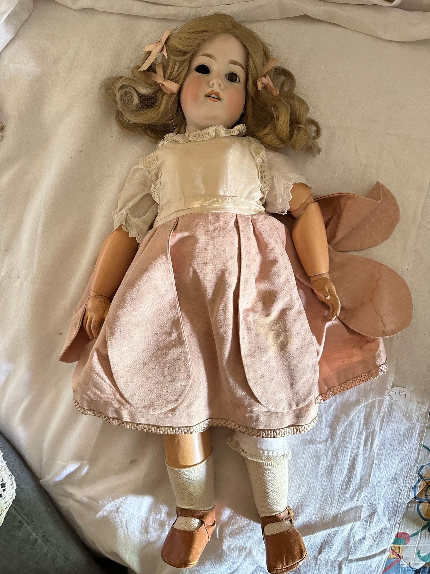 ARMAND MARSEILLE 
Doll, porcelain head, brown mobile eyes, mouth open over 2 teeth. Body in articulated composition. Pink cotton skirt, white silk blouse. 
Marked A9M 390M. 
H. 69 cm
(One eye to be reattached).