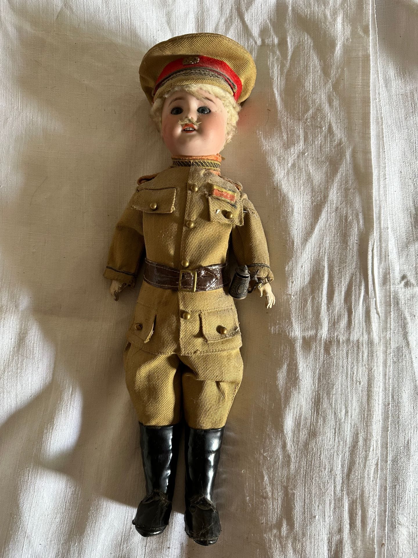 S.F.B.J. 
Poupée n°60, la tête en porcelaine, les yeux bleus mobiles, la bouche ouverte sur 4 dents. Corps en composition articulé. Habit d'officier allemand. 
H. 37 cm
(Accidents et usures).