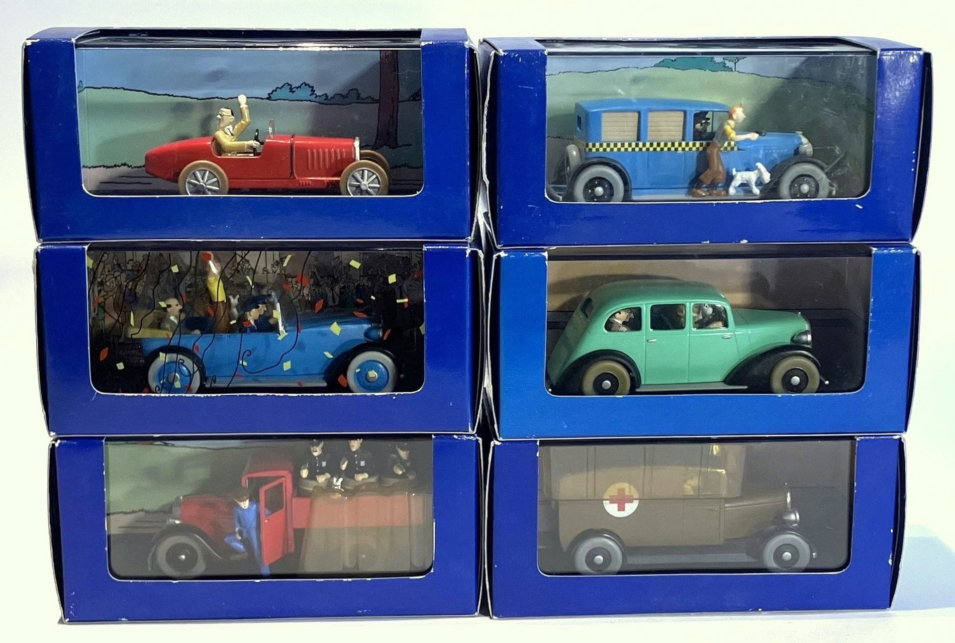 TINTIN EN AMÉRIQUE – EN VOITURE TINTIN 
Lot de 6 modèles réduits. Éditions Atlas Hergé/Moulinsart, années 2000, dans leur boîte d’origine : 
- Le camion de police de Chicago, International, 1930, réf. 2118041, 
- La voiture d’apparat, années 20, réf. 2118039, 
- Le bolide de Bobby Smiles, Bugatti Type 37 Sport, 1926, réf. 2118054, 
- Le taxi, taxi Cheker, 1929, réf. 2118004, 
- La voiture des gangsters, Graham Six, 1935, réf. 2118058, 
- L’ambulance de Chicago, années 20, réf. 2118051.