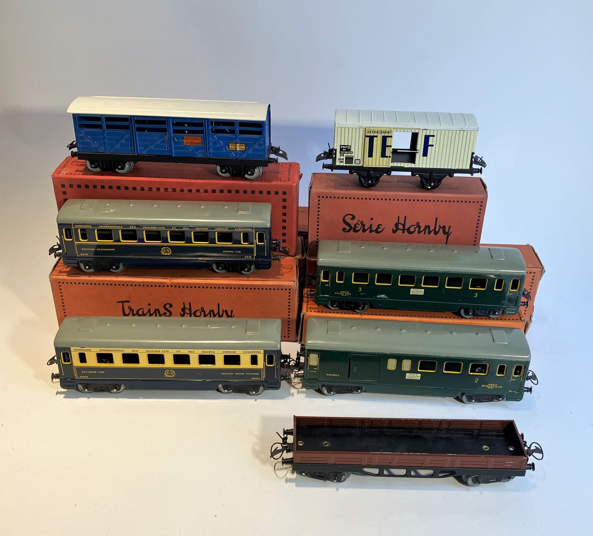 TRAINS HORNBY - SÉRIE HORNBY 
Lot de 7 wagons : wagon à bestiaux n° 2, voiture voyageur OV, voiture mixte OM, voiture Pullman Vo OP, wagon frigorifique IS STEF, wagon ridelles basse, voiture restaurant Vo OR.

On joint : 
TRAINS HORNBY - SERIE HORNBY 
Cabine sémaphorique démontable, viaduc démontable, gare n° 19 (Marseille) démontable, gare n° 21 (Bordeaux Saint-Jean) démontable