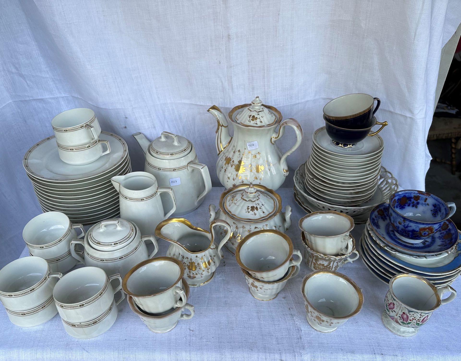 Lot de 2 services à café en porcelaine, l'un de style Art Déco et l'autre Vieux Paris. 
On joint des assiettes, tasses et plats de styles divers.