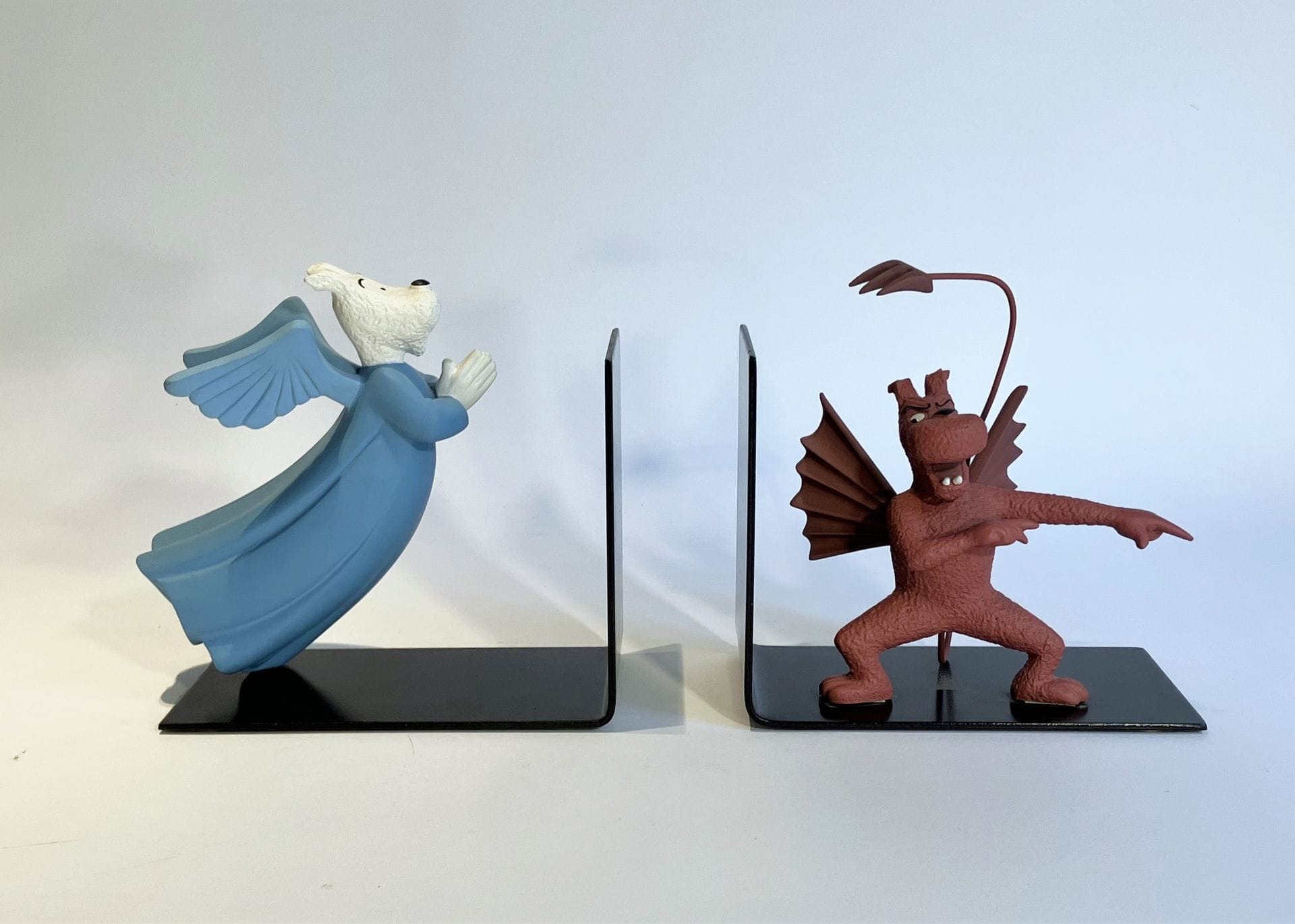 MILOU ANGEL & DEMON 
Pair of bookends in polychrome resin and black lacquered metal. Made by Leblon-Delienne in 1991.
H. 17 cm