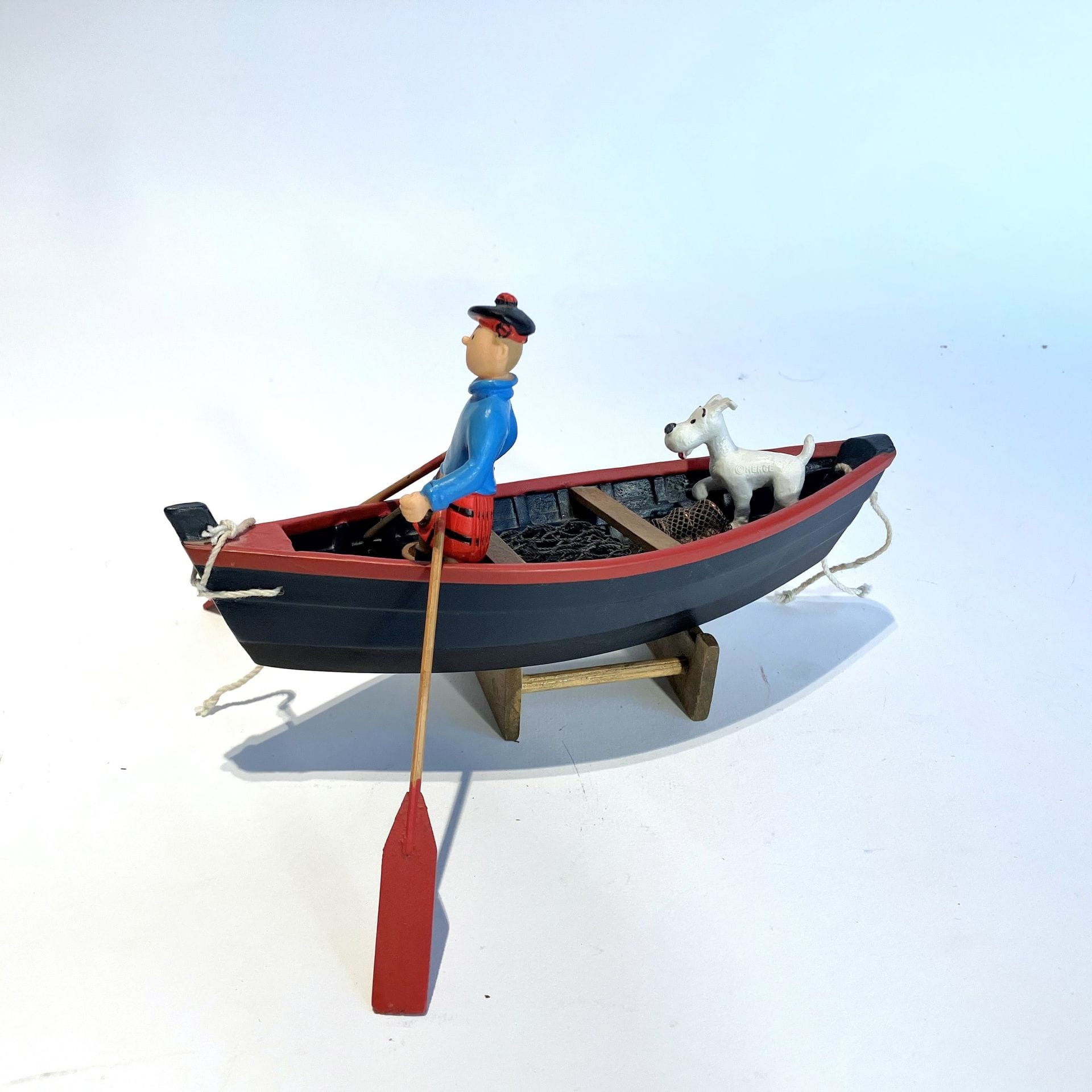 THE BLACK ISLAND
Tintin and Snowy on a boat
Polychrome resin figures on a wooden boat. Éditions Hergé (mark under the figures).
L. boat 19cm - Height. Tintin 8 cm