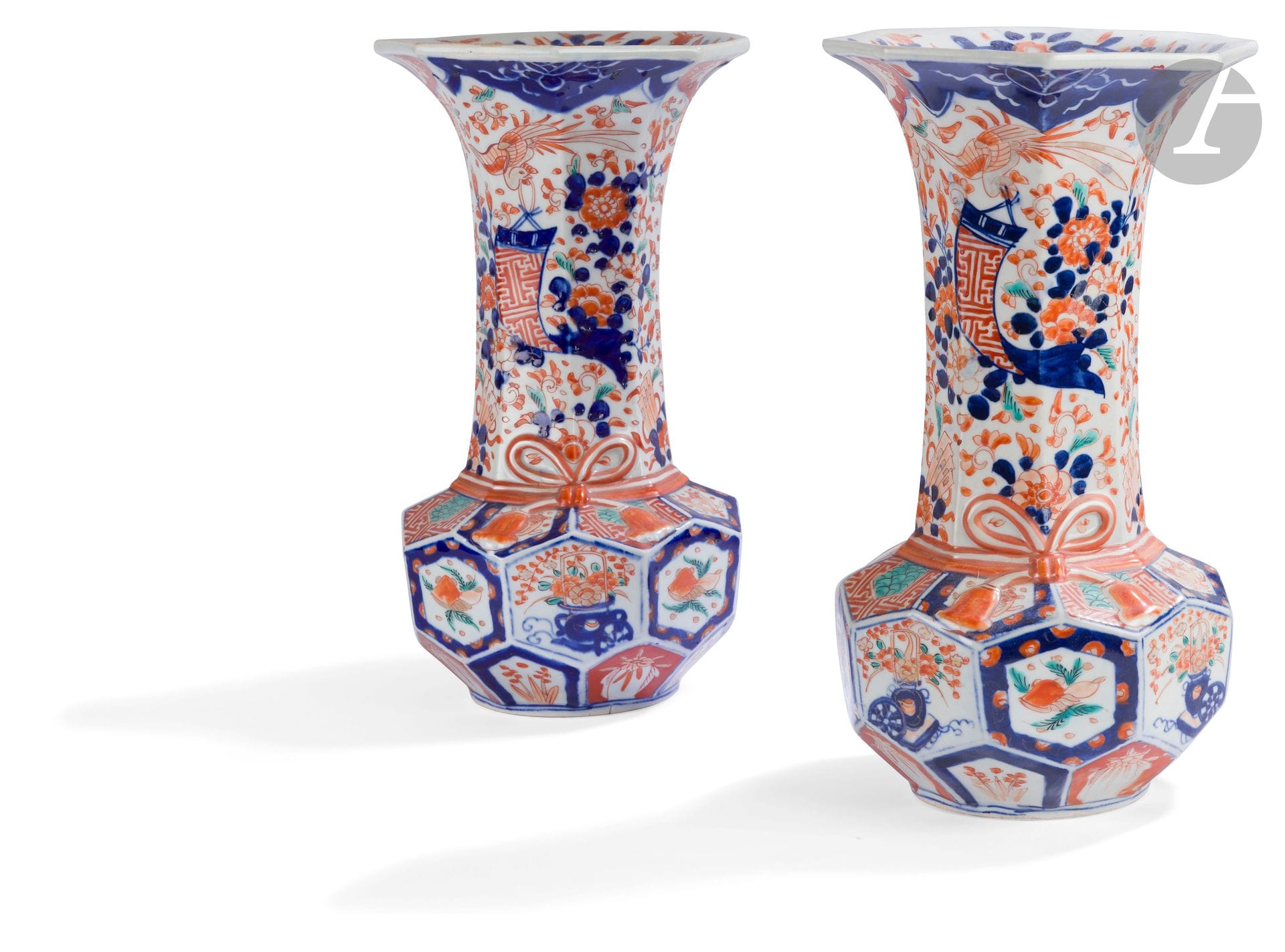 Japon 
Paire de vases cornet à panse octogonale en porcelaine à décor bleu, rouge, vert et or Imari de corbeilles fleuries, phénix, fleurs, éventails et fruits. 
XIXe siècle.  
H. 33 cm.
