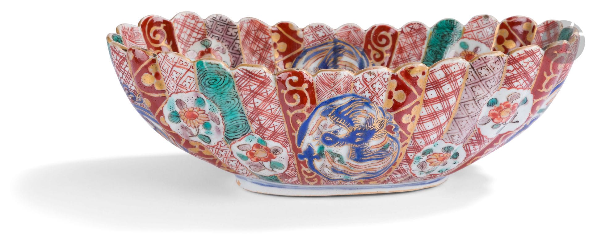 Japan 
Porcelain oval cup with blue, red, green and gold Imari decoration of phoenixes and florets in medallions on a background of alternating stripes. 
19th century.  
L. 24 cm.