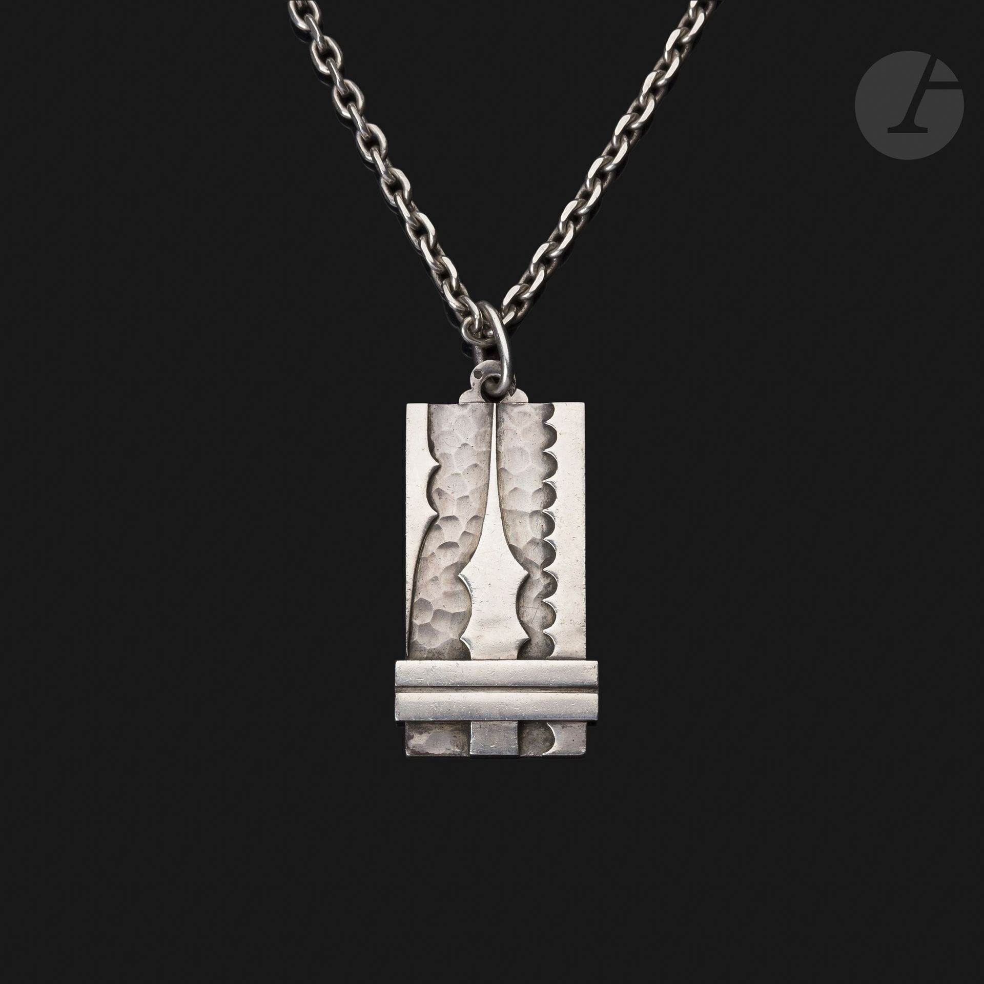 JEAN DESPRÉS (1889-1980)
Modernist silver pendant and chain. The pendant is decorated with applications of free-form motifs and barrettes on a hammered background on one side. Signed J. DESPRÉS at the point on the back of the pendant and bearing the Master Goldsmith and guarantee hallmarks on the ring and pendant. Weight : 90 g

Provenance :
- Former Avallon Collection of Mr. &amp; Mrs. X., acquired by them directly from the artist.
- Sale Arts Décoratifs et Sculptures du XXe siècle - Ader maison de ventes, Hôtel Drouot, December 2, 2016. Work presented under number 94 in the catalog.
- Private collection. Work acquired at the previous auction.
