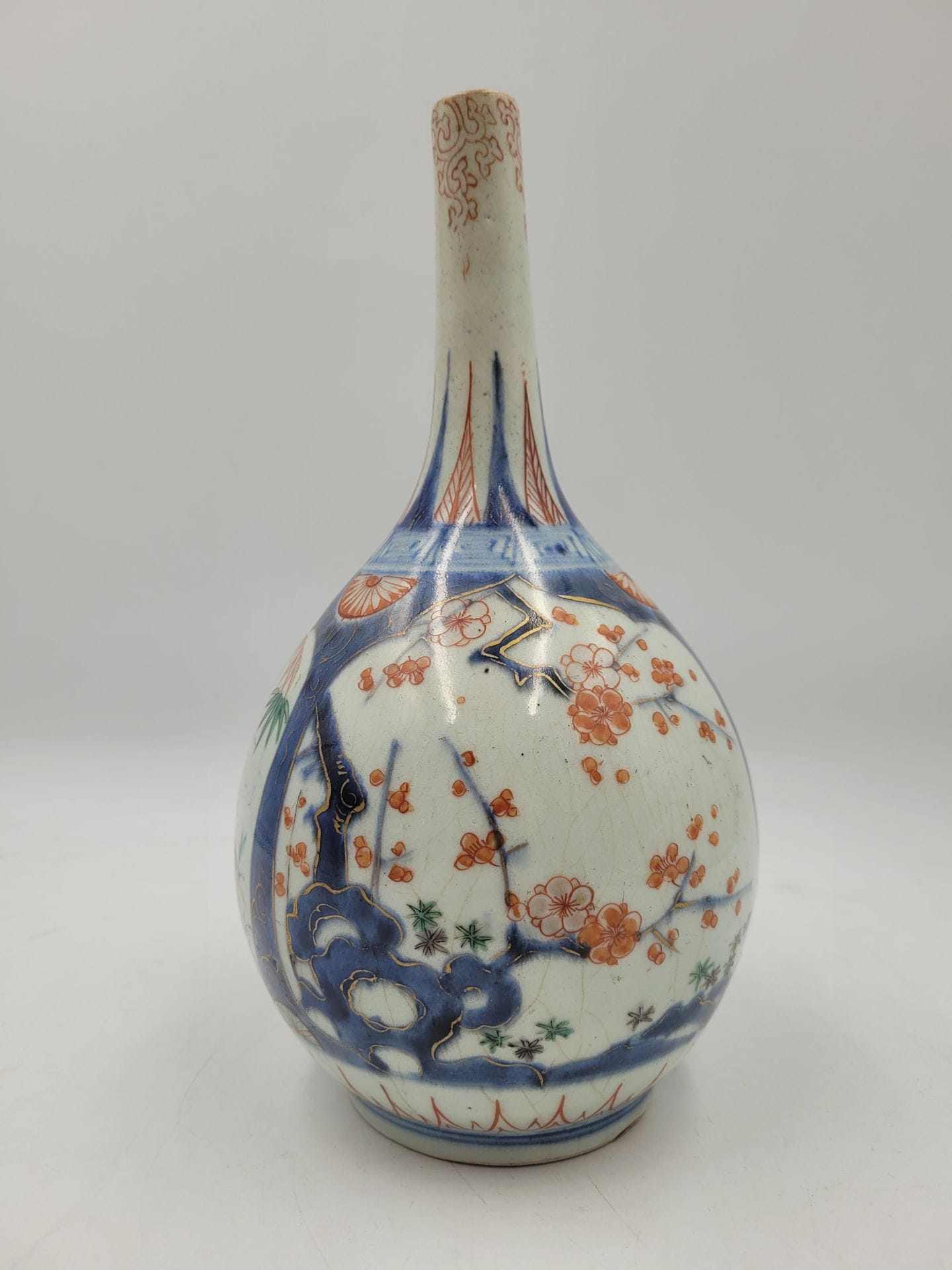 Imari porcelain bottle vase, Japan, 18th century
Decorated in underglaze blue and overglaze red, gold and green enamels in reserves with the three friends of winter (plum, bamboo and pine). The neck is decorated with tako karakusa (octopus tentacles) enameled in red over glaze.
Height: 23.4 cm
Remains of a Bd Haussmann store label.