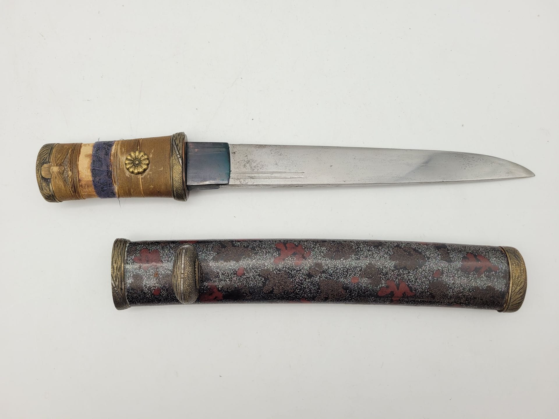 Aikuchi Tanto, Japon, époque Meiji
Lame de type Kanmuri-otoshi.
Double et simple gorge, repolie, traces de rouille.
Montures en suite époque Meiji, manque le kogatana, tsuka-ito abîmé.
Traces de restauration.