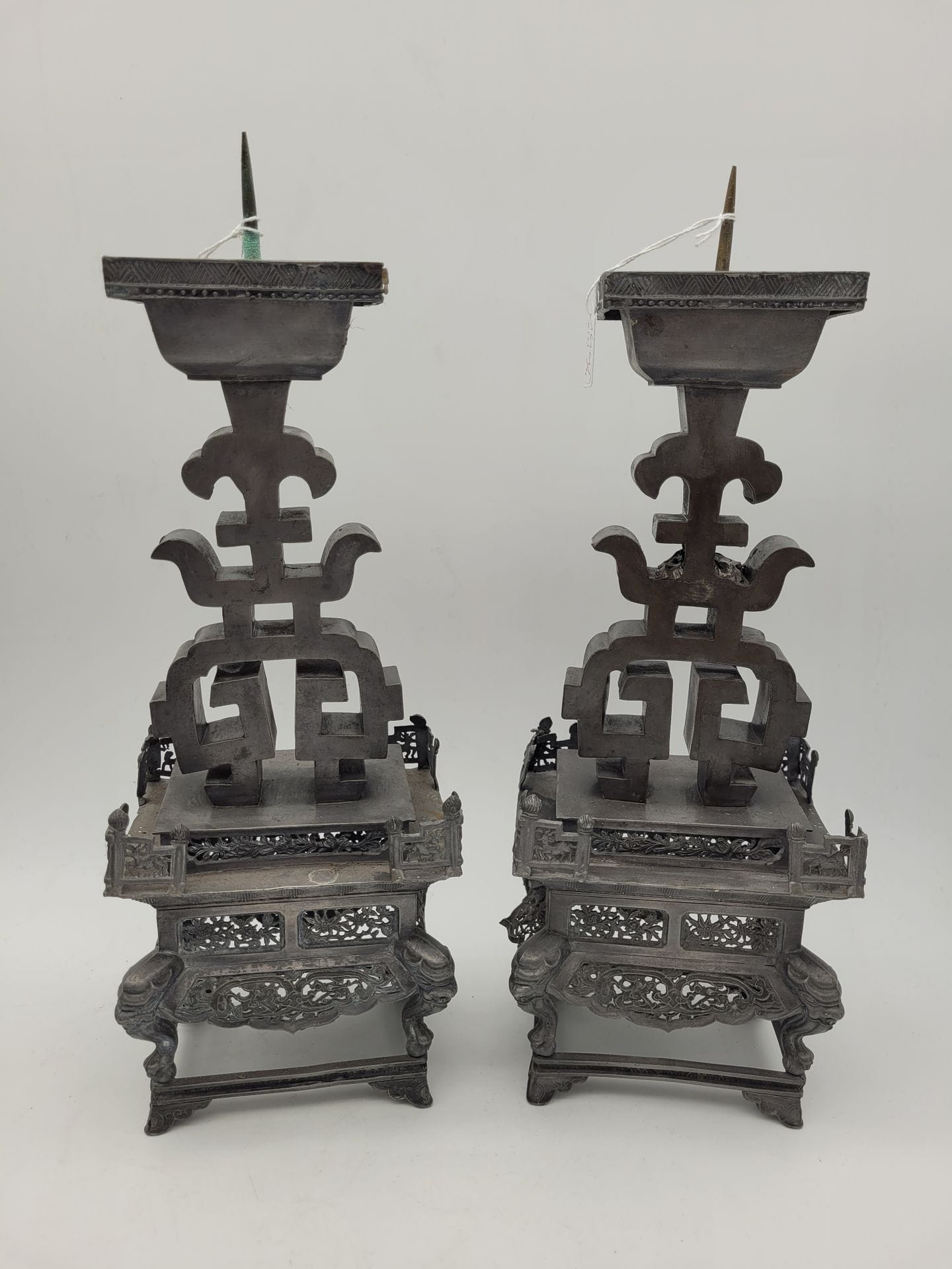 Paire de bougeoirs en étain, Chine, XIXe siècle
Les fûts à décor d'un signe shou reposant sur une terrasse munie de petites balustrades ajourée de motifs de daim et d'oiseaux dans des rinceaux. Au-dessous, un socle à décor ajouré de fleurs, dragons, chauves-souris et phénix, terminé par quatre pieds à tête d'animal mythique et pattes griffues posées sur une boule. L'ensemble sur un dernier petit socle à pieds courts. Les bobèches de forme rectangulaire.
Hauteur : 35 cm