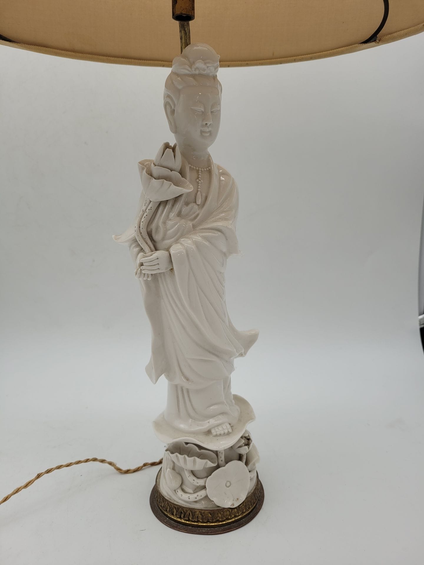 Guanyin in Chinese white porcelain, China, 19th-20th century
Standing on a lotus base, wearing a long robe and necklace, right hand holding a lotus flower.
Height: 30.5 cm
Mounted as a lamp.