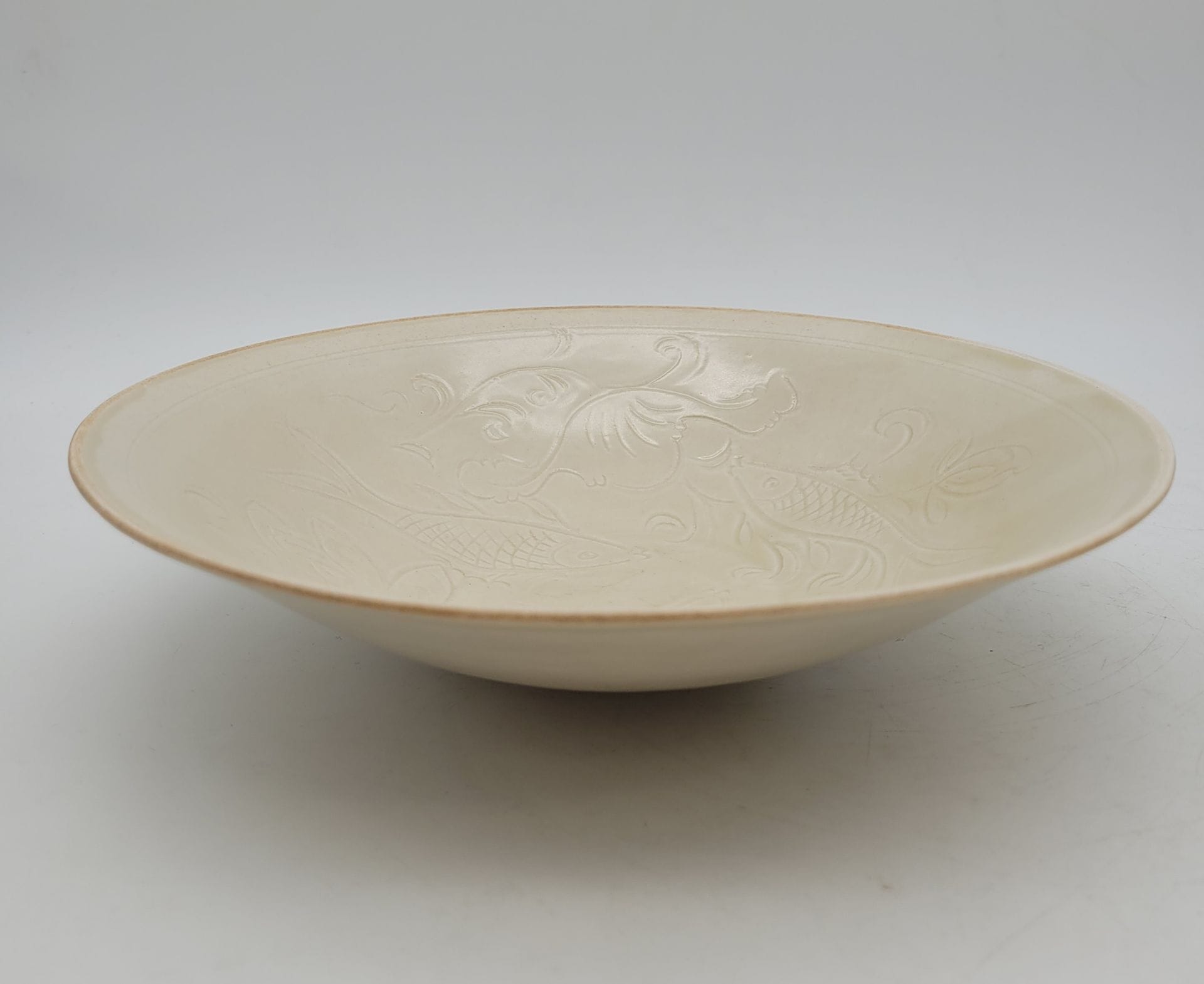 Porcelain bowl, China, 20th century, Ding porcelain style of the Song period
With incised fish and lotus decoration.
Diameter: 24.6 cm