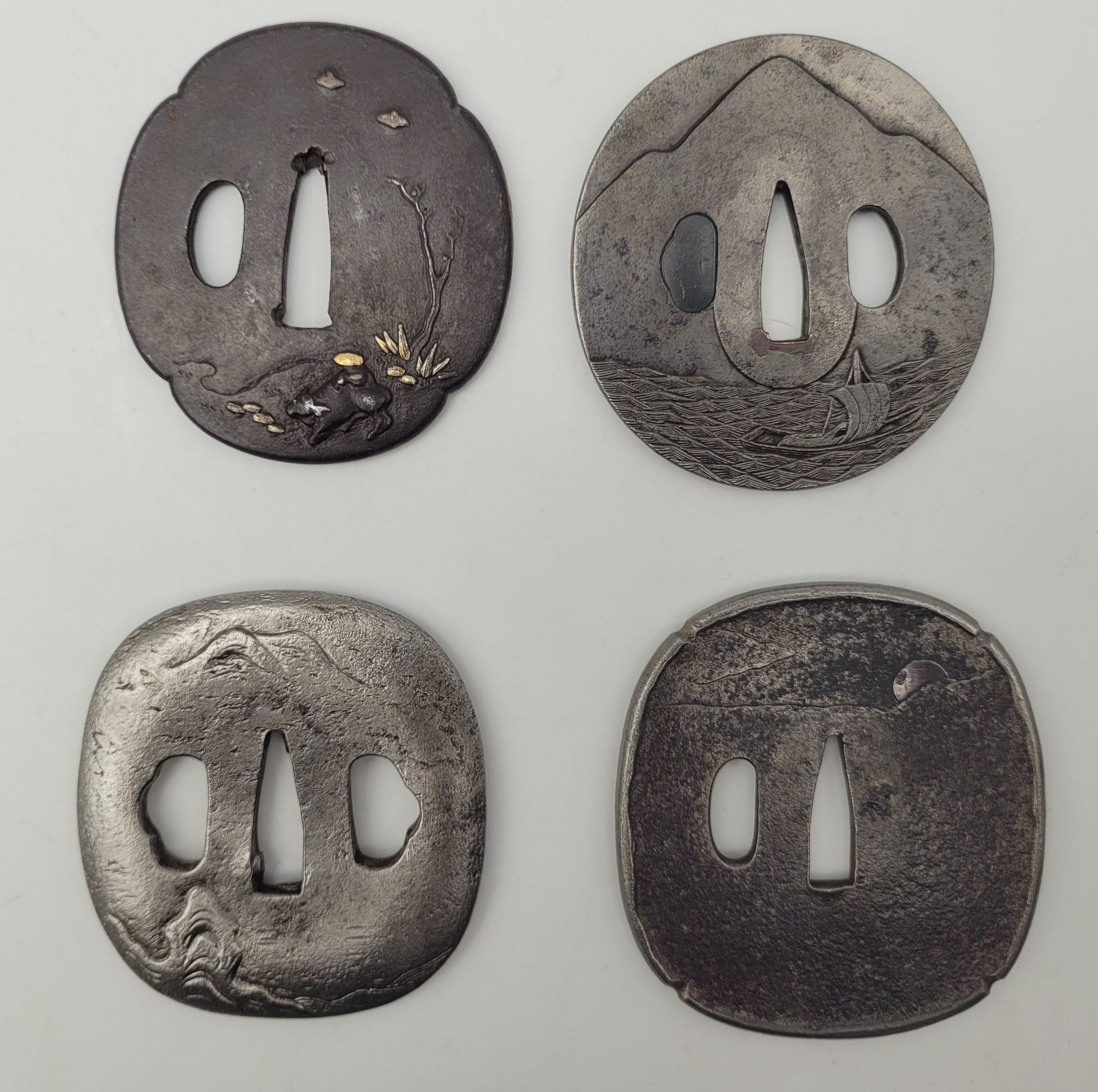 Lot de quatre tsuba en fer, Japon
Formes diverses (maru, mokko et kaku maru gata) à décors divers (bateaux, paysages animaux).
Deux signées.
Usures, manques, dépatinées.