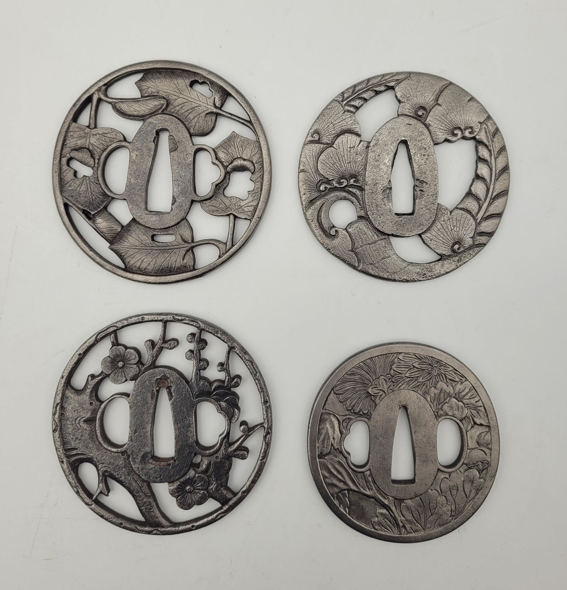 Set of four iron tsuba, Japan
Maru and naga maru gata forms with leaves and flowers.
One signed.
Worn, missing, de-patinated.