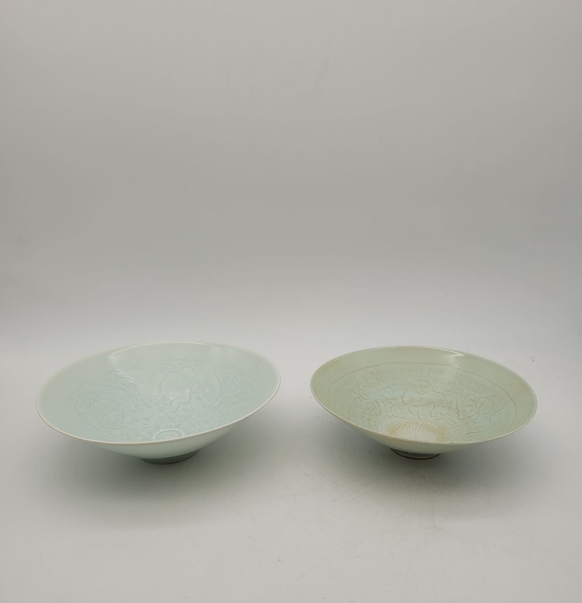 Deux bols en porcelaine, Chine, XXe siècle, style des porcelaines Qingbai de la dynastie Song
A couverte bleu pâle, et décor incisé de rinceaux et de jeunes garçons stylisés.
Diamètre : 19,5 et 20,5 cm
Petits éclats au talon pour un.