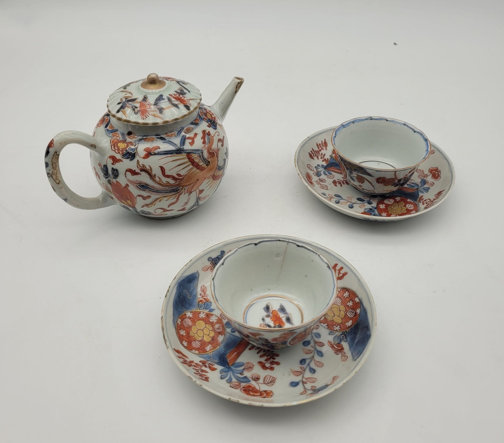 Set of porcelain with Imari decoration, China, 18th-19th century
- 1 teapot with phenix design
- 2 cups and 2 saucers with floral decoration
H. teapot: 10 cm; H. cups: 3.7 cm; diam. saucer: 12.4 cm
Small chips and cracks.