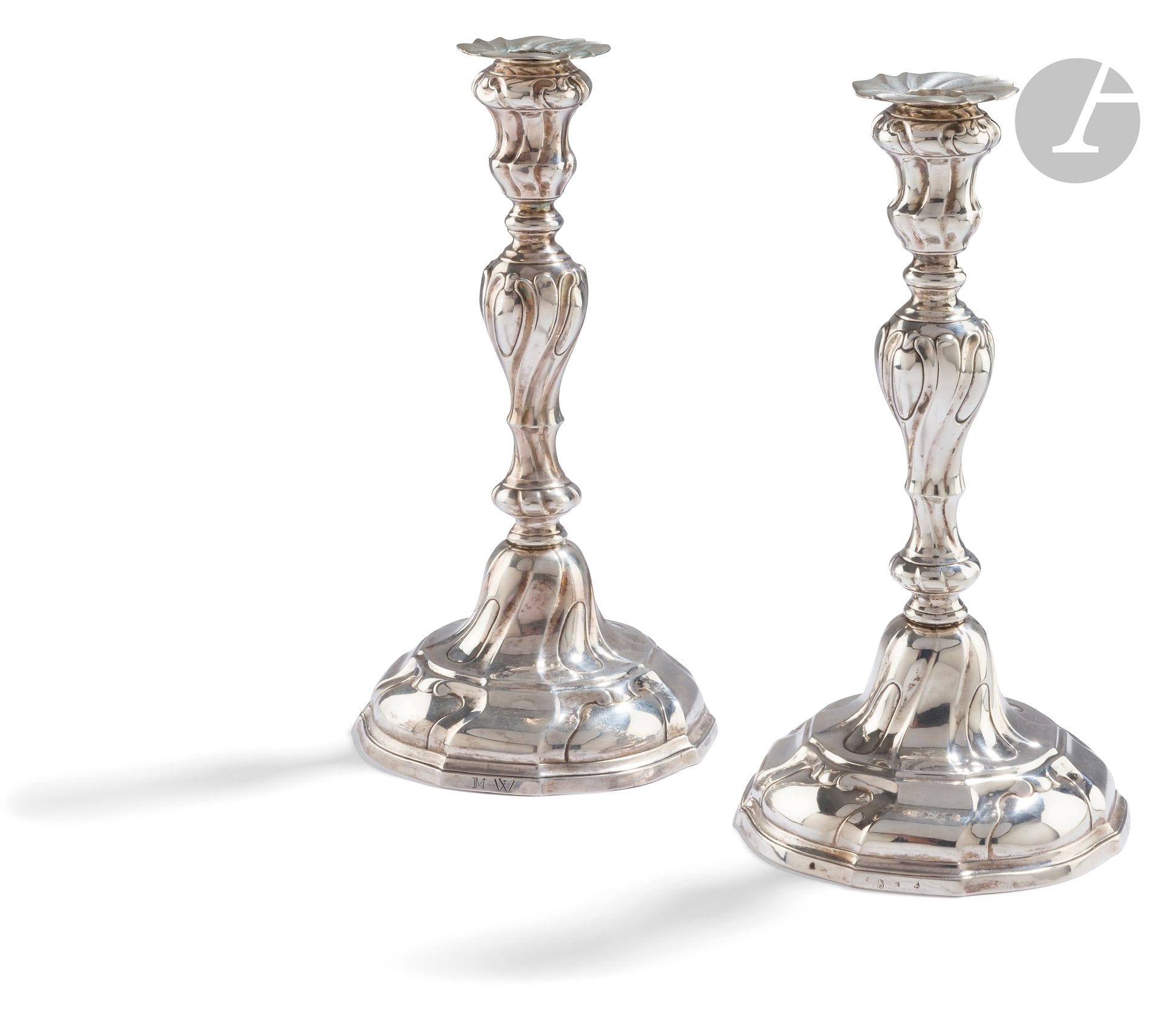 VILLE DE TOURNAI 1773 - BELGIUM
Pair of silver candlesticks and two bobèches repoussé with twisted ribs of two sizes and medallions all over the body, the base poly-lobed. Engraved with the letters MW around the rim.
Master goldsmith : illegible
Weight: 606 g - height: 26.7 cm