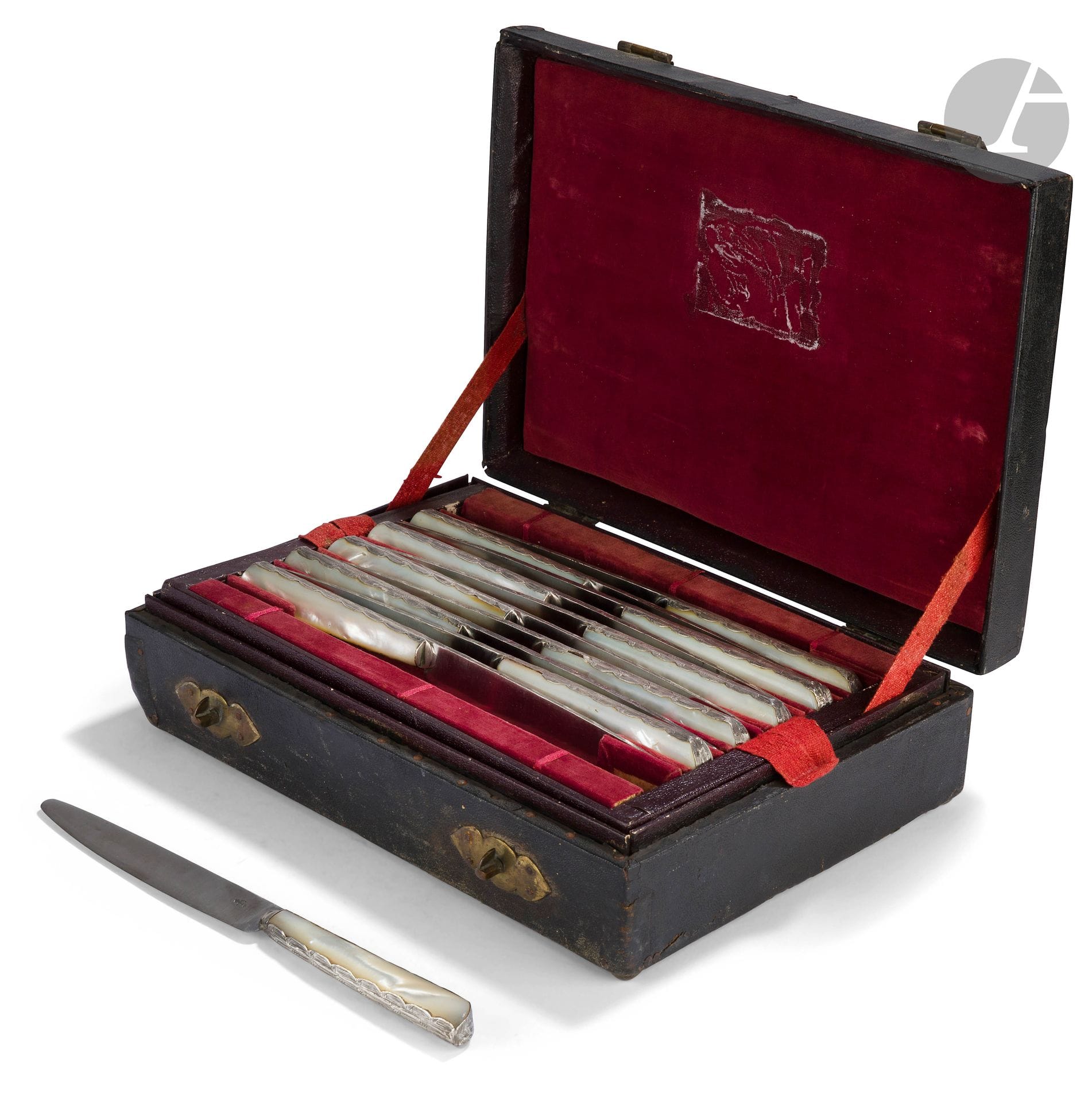 FRANCE milieu du XVIIIe siècle
Dans un coffret de transport en chagrin noir ouvrant à charnière et poignée centrale, ensemble de onze couteaux de table, le manche en nacre serti d'une feuille d'argent ciselée de feuillages sur le pourtour se prolongeant sur la lame en acier, marquée d'un poinçon de maître coutelier : une fleur de lys (marque commune dans nombre de bassins couteliers anciens).
Poids brut : 894 g - longueur : 23,8 cm
Travail attribué au bassin coutelier champenois : Nogent ou Langres
Les couteaux en excellent état, le coffret à l'état d'usage (fentes au cuir)