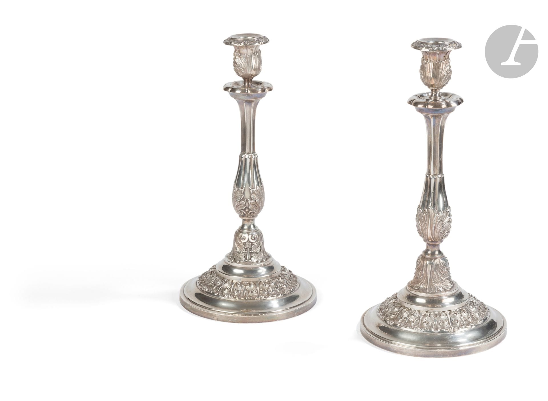 FRANCE 19th century
Pair of silver torches and their wicks resting on a circular base. The base, the start of the shaft, part of the shaft and the spigot are embossed with acanthus leaf motifs. 
Minerve hallmark
No apparent goldsmith
Weight : 2006 g - height : 36.4 cm - base diameter : 18.3 cm