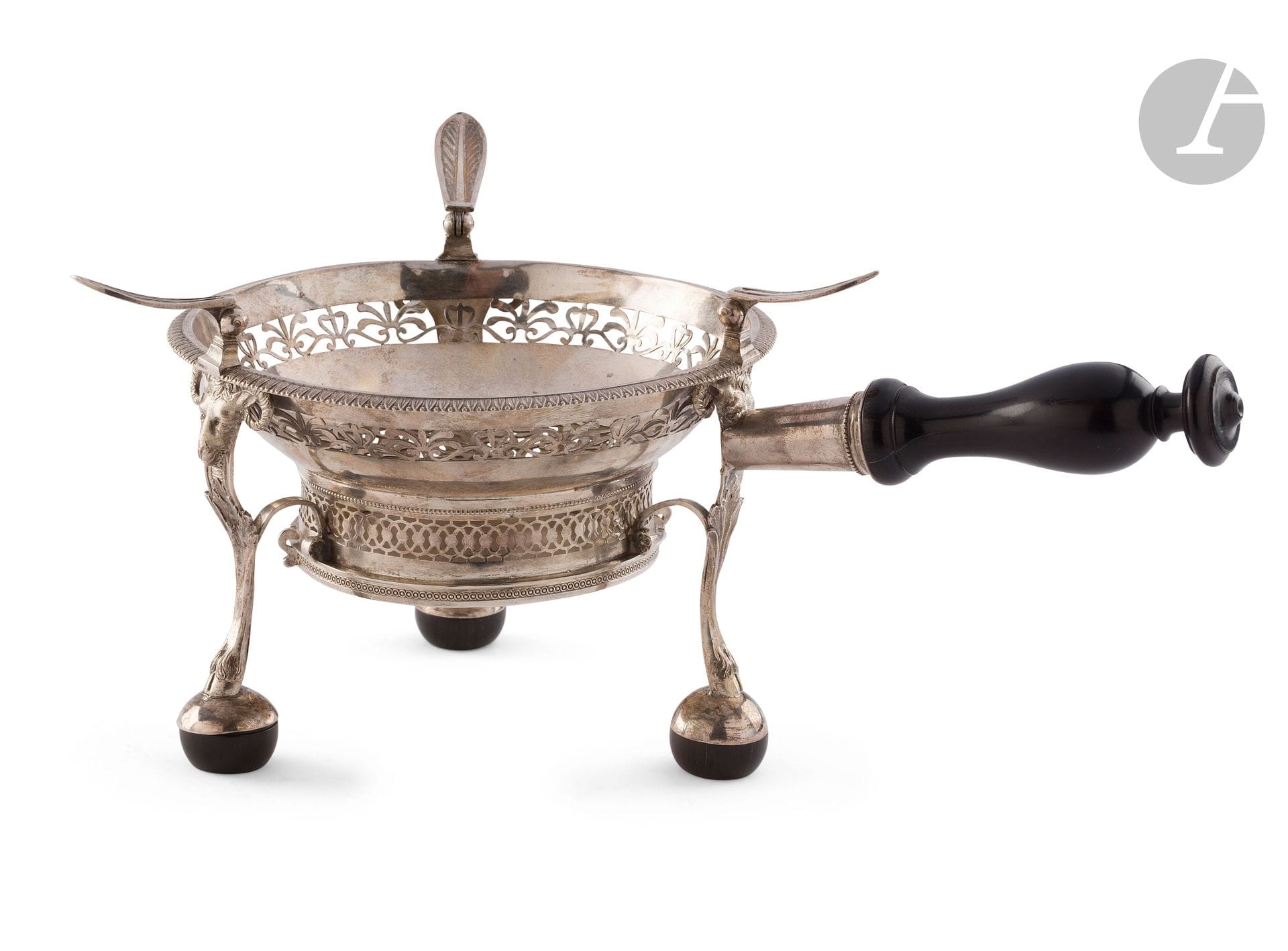 NORTHERN FRANCE 1809 - 1818
Circular silver stove with openwork fleuron and lattice motifs, resting on three ball feet embellished with ram heads, turned wooden handle resting on a long hood.
Unidentified silversmith: BD
Different small guarantee hallmark: 72 for the towns of Dunkerque, Valenciennes or Lille.
Gross weight: 603 g - diameter: 17.5 cm - height: 11.5 cm