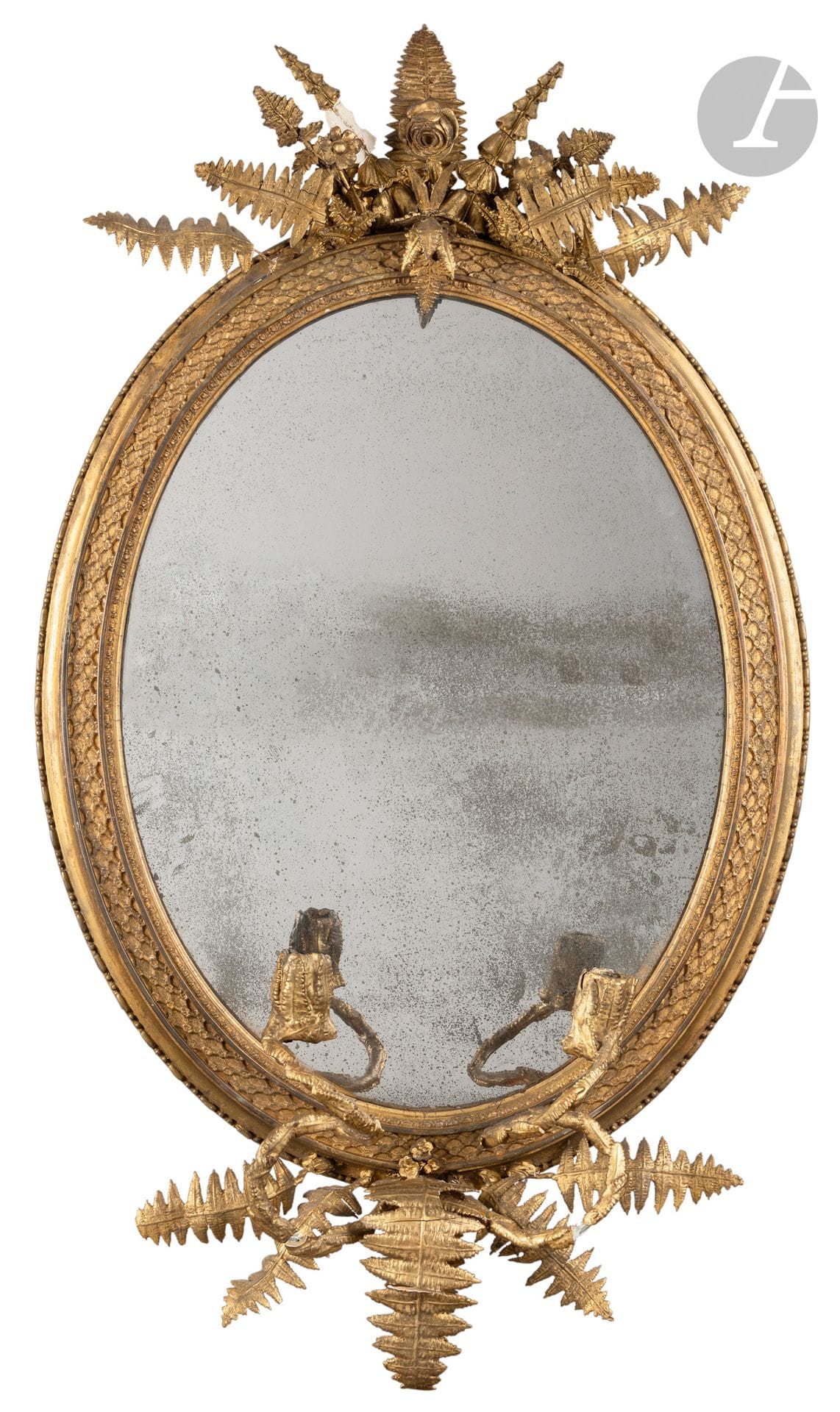Miroir porte-lumière en bois, stuc et laiton ou tôle dorée, à deux bras de lumière et décor de treillages et fougères ; (accidents et manques).
XIXe siècle.
H. 95 cm, L. 57 cm (approx.) 

Un miroir similaire a été vendu à Nevers, Métayer Mermoz, le 31 janvier 2021, lot 408.