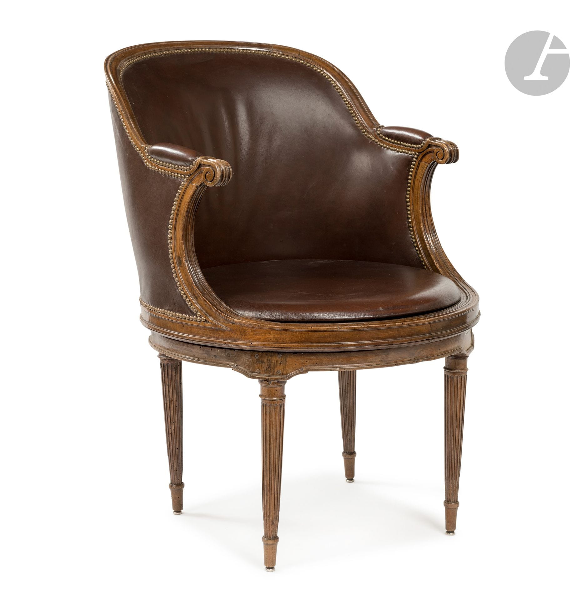 Fauteuil de bureau à assise tournante en noyer mouluré dans le goût de Georges Jacob, à dossier arrondi en gondole, les supports d'accotoir galbés dans le prolongement de l'assise circulaire reposant sur des pieds fuselés à cannelures ; (petits accidents).
Époque Louis XVI.
H. 91 cm, L. 59 cm