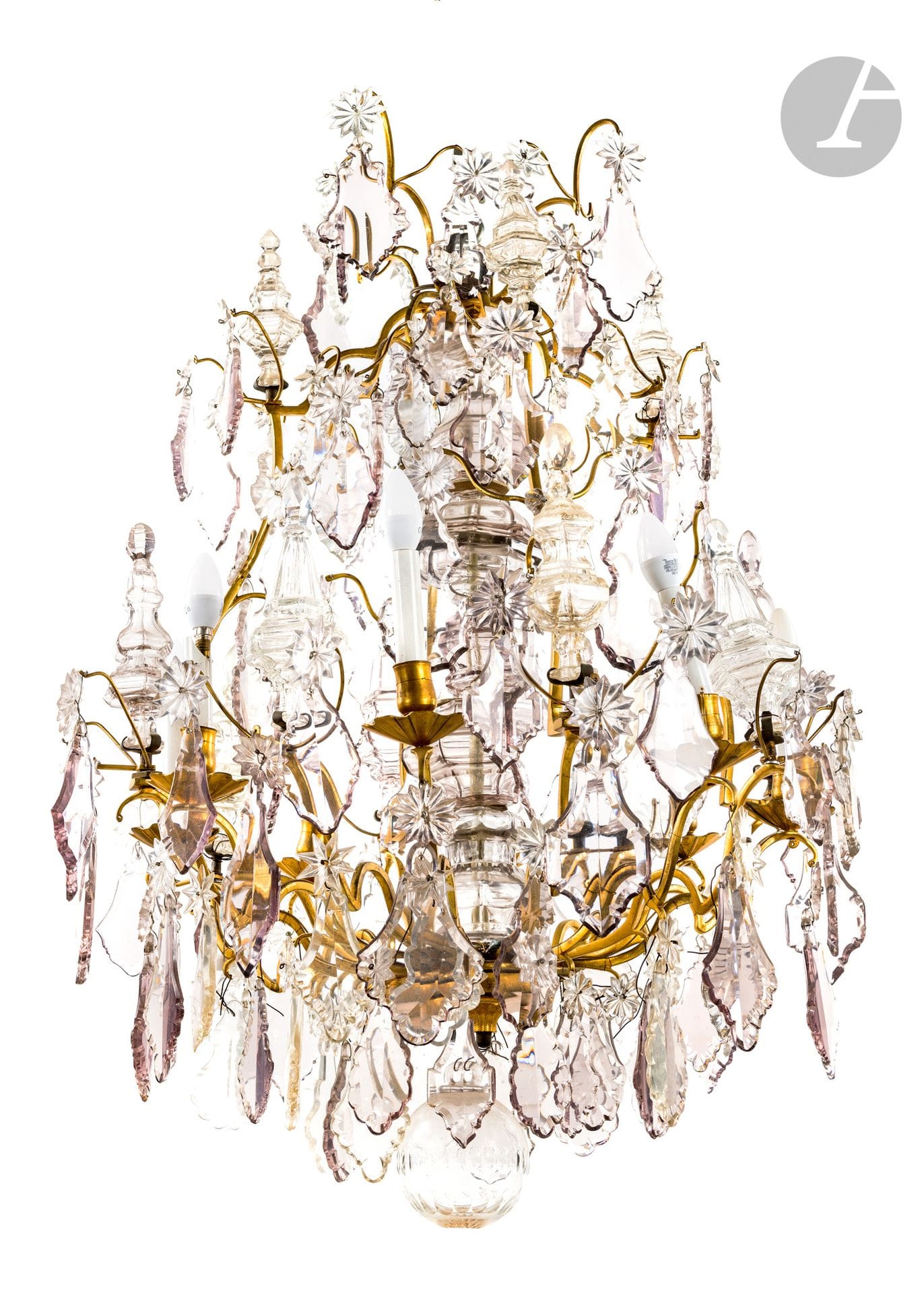 Lustre en bronze doré et verre taillé, à huit lumières, à décor de pendeloques, étoiles et pinacles (les éléments de verre rapportés à une date ultérieure) ; (accidents, restaurations et manques).
En partie d'époque Louis XV.
H. 100 cm, L. 75 cm