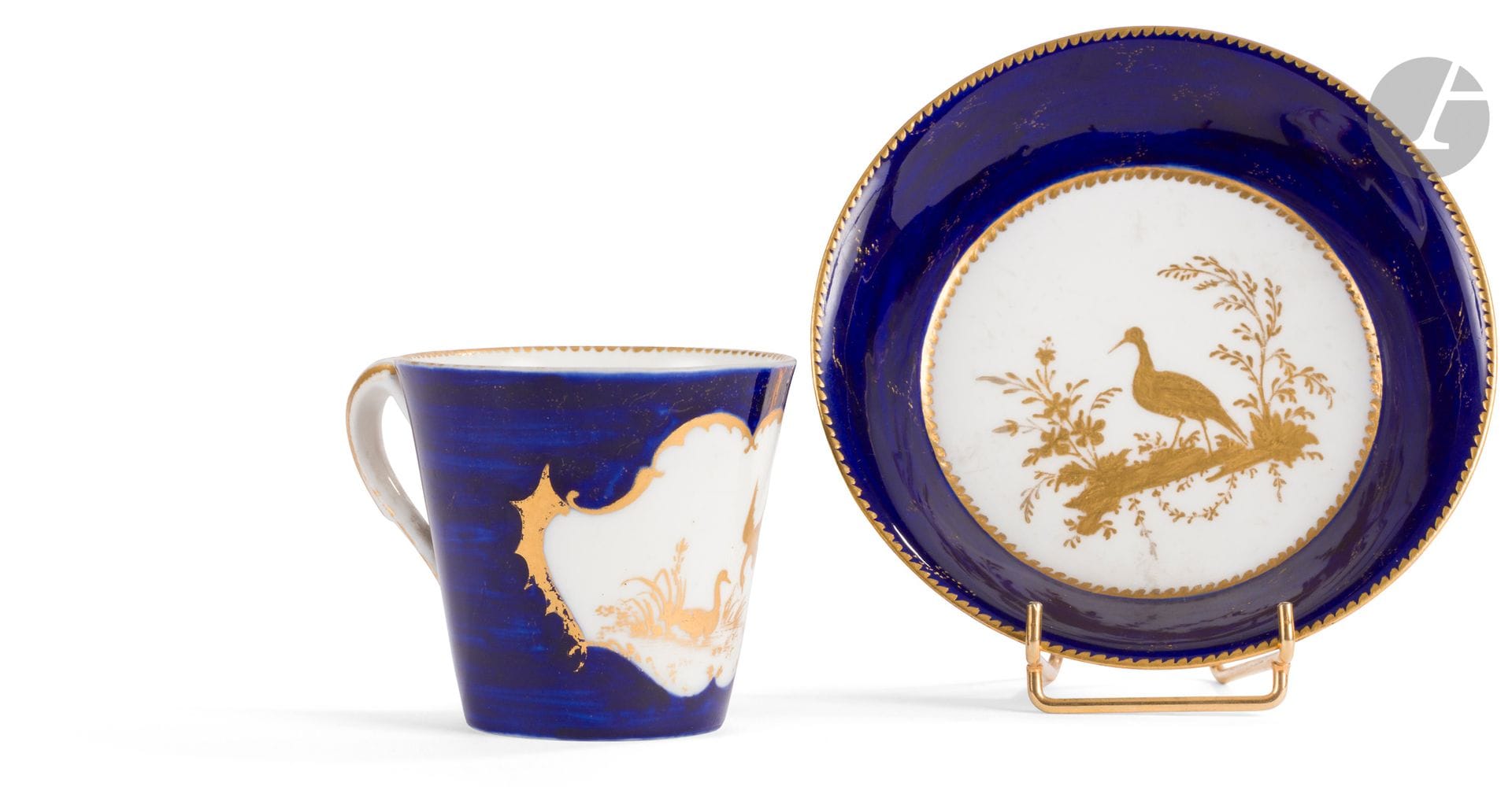 Vincennes
Gobelet à la Reine et sa soucoupe en porcelaine tendre à décor en or d'oiseaux sur terrasse sur fond bleu lapis, la réserve du gobelet encadrée de motifs d'ailes de chauve-souris en or.
Marqués : LL entrelacés, sans lettre-date.
XVIIIe siècle, vers 1752-1753.
H. 7 cm, D. 13,5 cm
Quelques usures d'or.