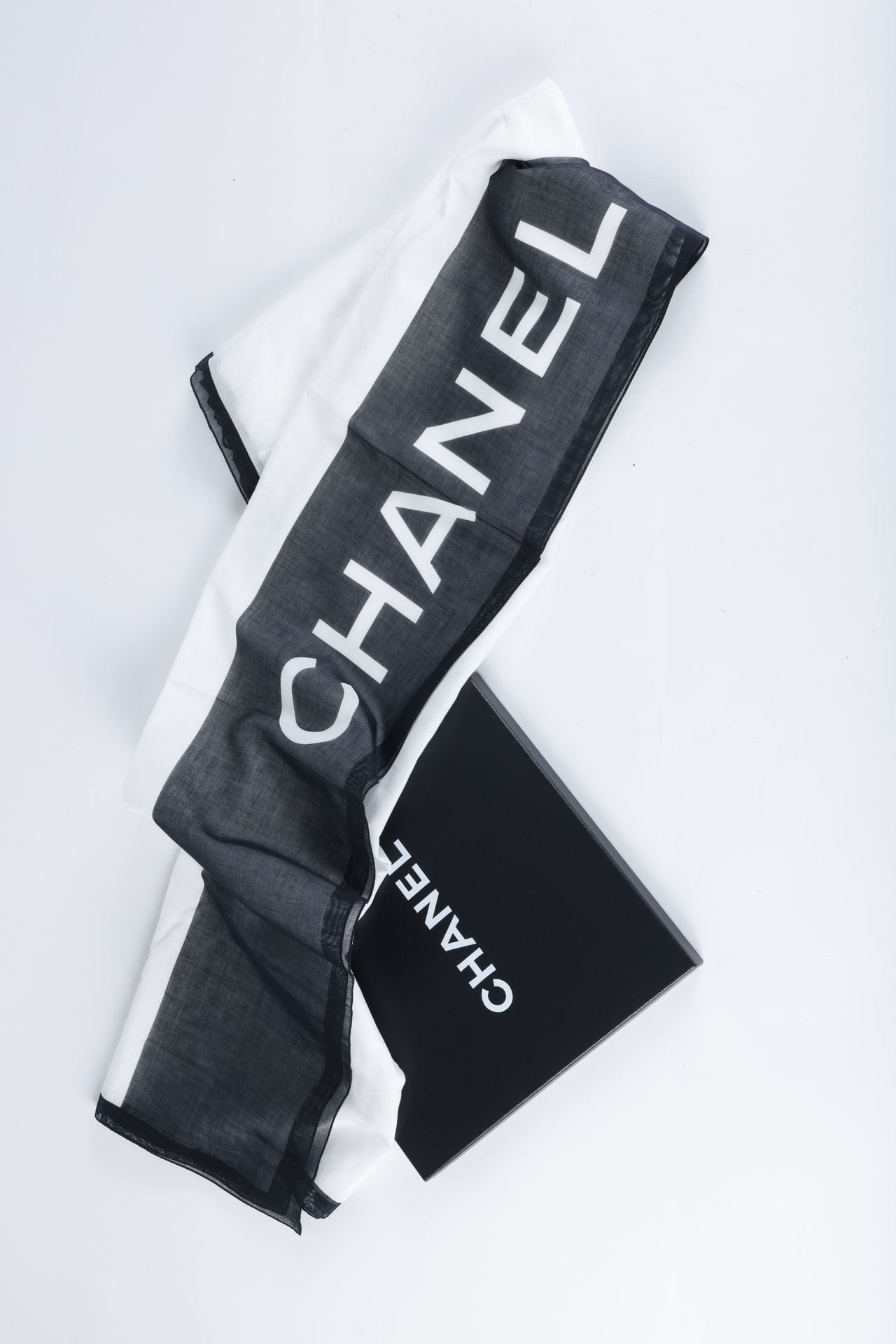 CHANEL
Paréo en voile de coton noir et blanc, 176 x 140 cm, dans sa boîte