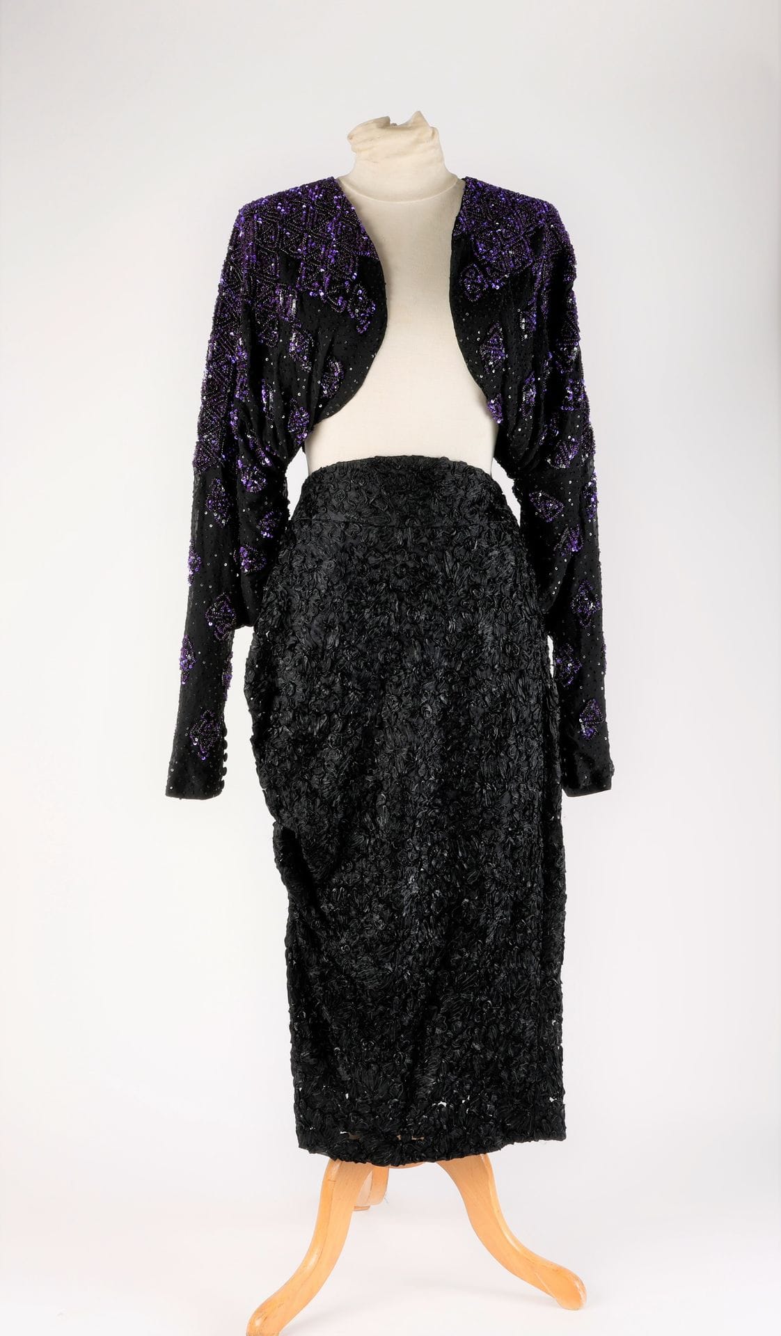 Guy LAROCHE Haute Couture
Two-piece: bolero in black crepe embroidered with pearls and purple sequins, asymmetrical skirt in black tulle and ribbon embroidery, S.36 approx.