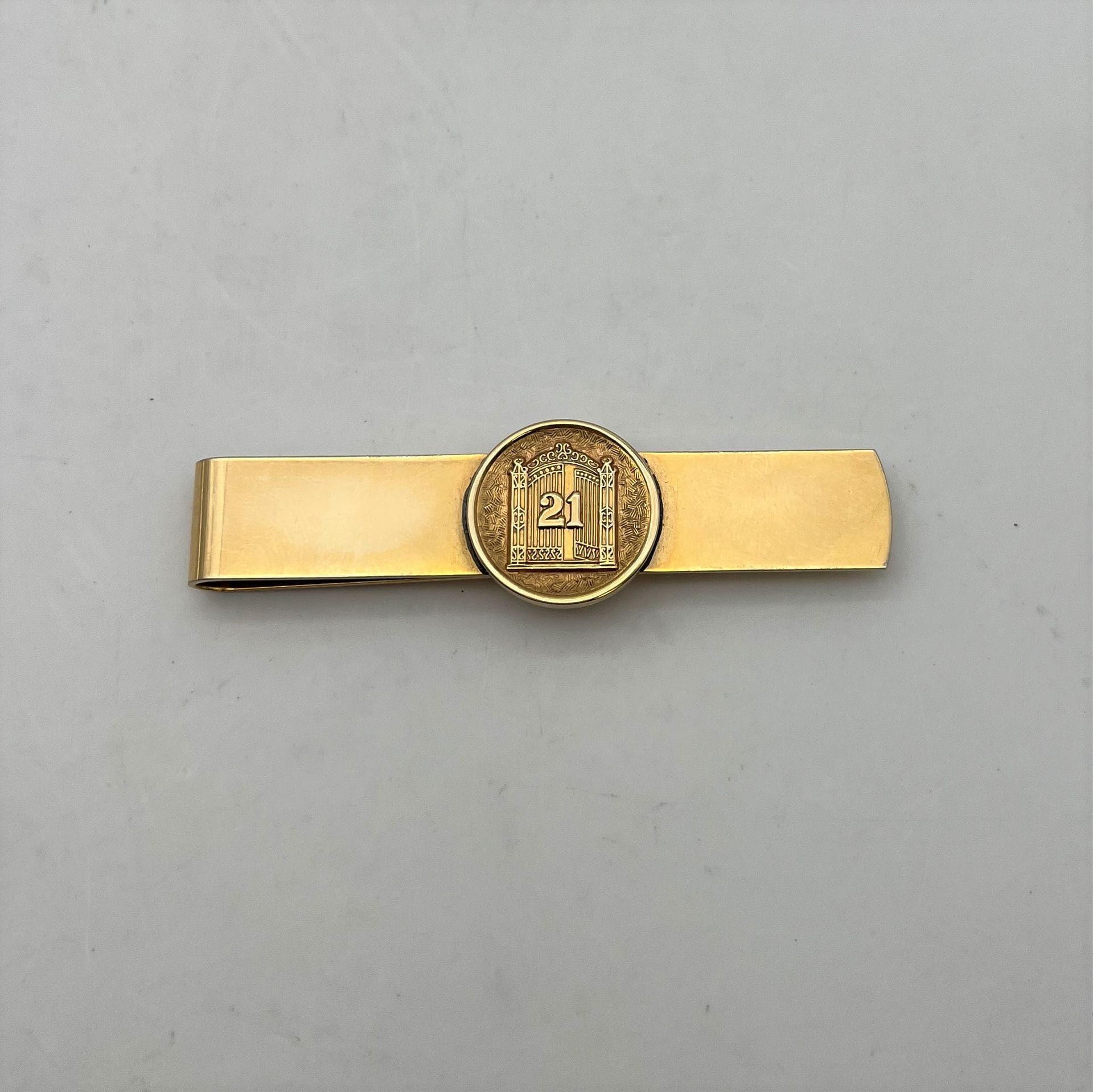 Pince à billet en or 12K à l'effigie du club 21.
poids net : 16.4 grammes.
débris.
Frais acheteur pièces et lots en or : 9,6% TTC -  8% HT