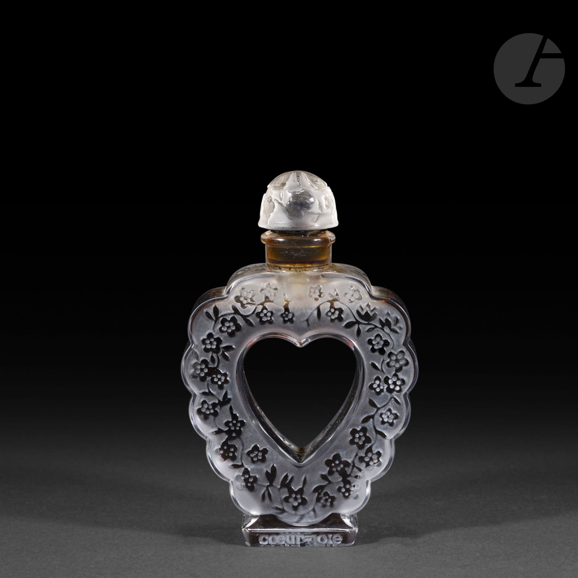 MARC LALIQUE (1900-1977) – MAISON LALIQUE
Cœur Joie, grand modèle, pour Nina Ricci, modèle conçu le 19 novembre [1942]
Flacon de parfum, le corps cordiforme au contour polylobé et le bouchon en calotte ronde. 
Épreuve en cristal soufflé-moulé pour la base et moulé-pressé pour le bouchon et, en partie satiné (Réf. Marcilhac Nina Ricci).
Signé LALIQUE ® en lettres cursives, à la pointe et titré Nina RICCI Made in France sous la base, titré et marqué Nina RICCI Cœur-Joie sur le talon.
Hauteur: 15 cm