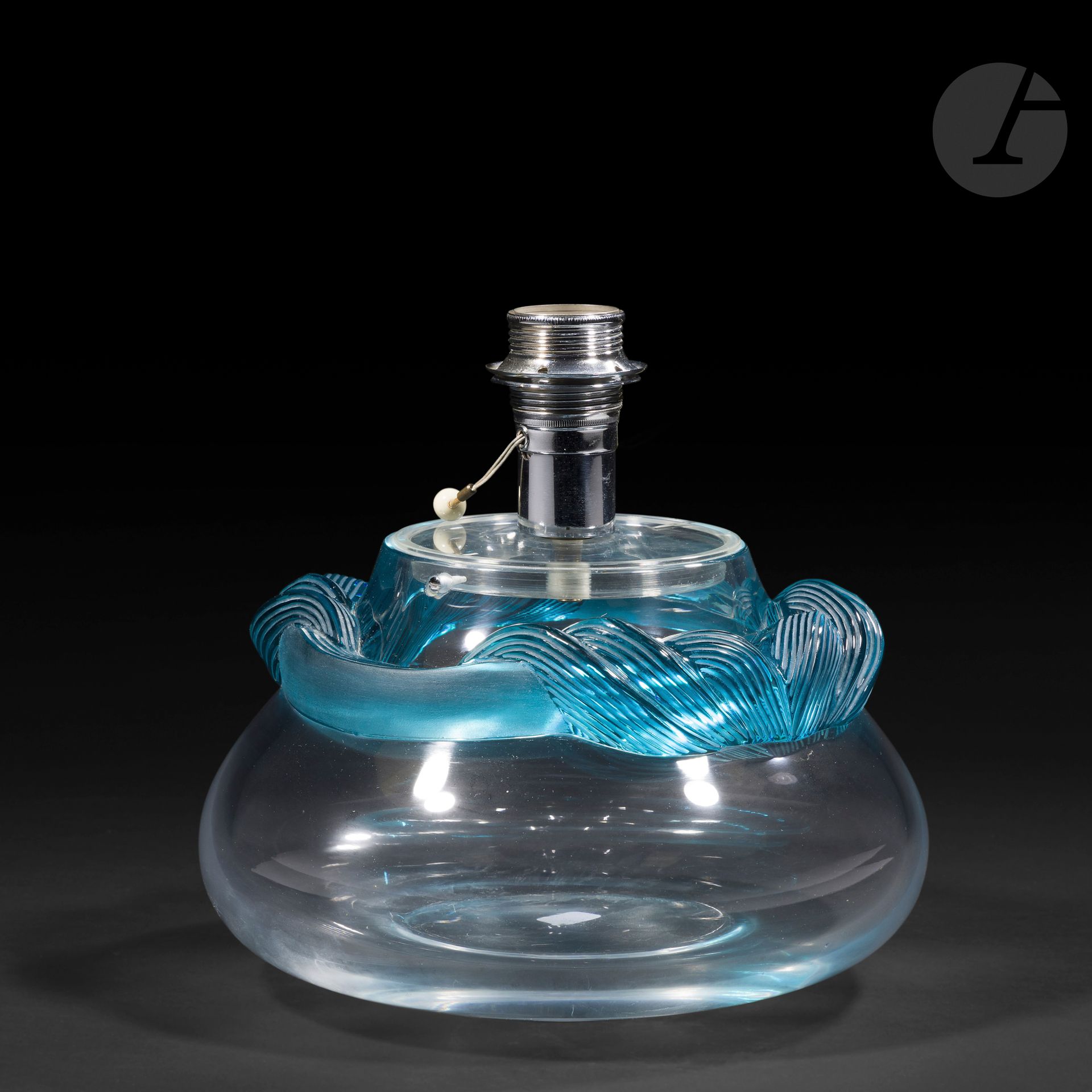 MARIE-CLAUDE LALIQUE (1935-2003) – MAISON LALIQUE
Cyrus
Pied de lampe bursaire; la base pouvant être isolée et former vase.
Épreuve en cristal soufflé-moulé au décor tournant d’un serpentin rainuré en cristal turquoise appliqué à chaud. 
Signé LALIQUE ® France en lettres cursives, à la pointe sous la base.
Hauteurtotale : 24,5 cm
Hauteur sans la douille: 16,2 cm