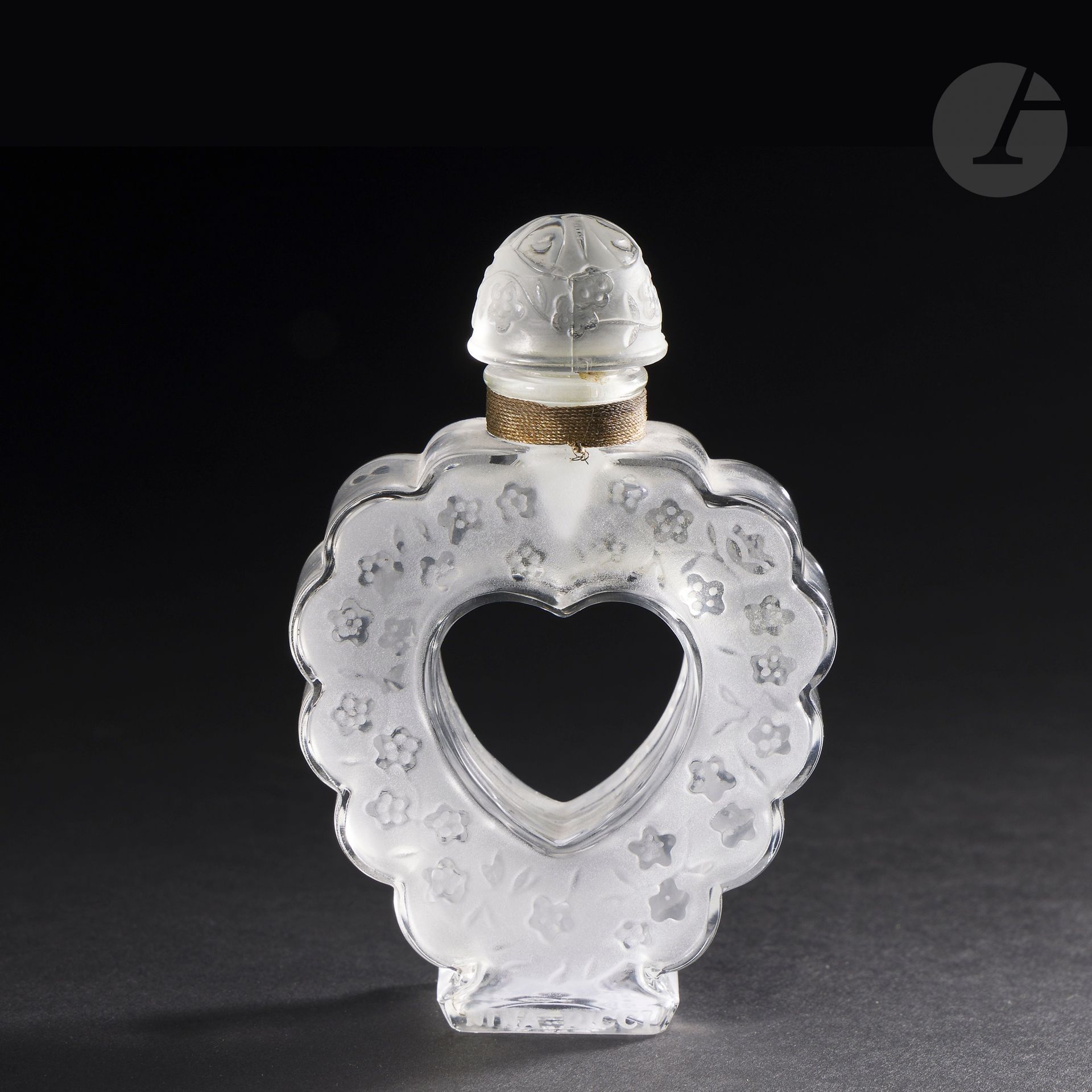 MARC LALIQUE (1900-1977) – MAISON LALIQUE
Cœur Joie, pour Nina RICCI, modèle conçu le 19 novembre [1942]
Flacon de parfum, le corps cordiforme au contour polylobé et le bouchon en calotte ronde. 
Épreuve en cristal soufflé-moulé pour la base et moulé-pressé pour le bouchon et, en partie satiné (Réf. Marcilhac Nina Ricci).
Signé LALIQUE ® en lettres cursives, à la pointe et titré Nina RICCI Made in France sous la base, titré et marqué Nina RICCI Cœur-Joie sur le talon.
Hauteur: 12 cm