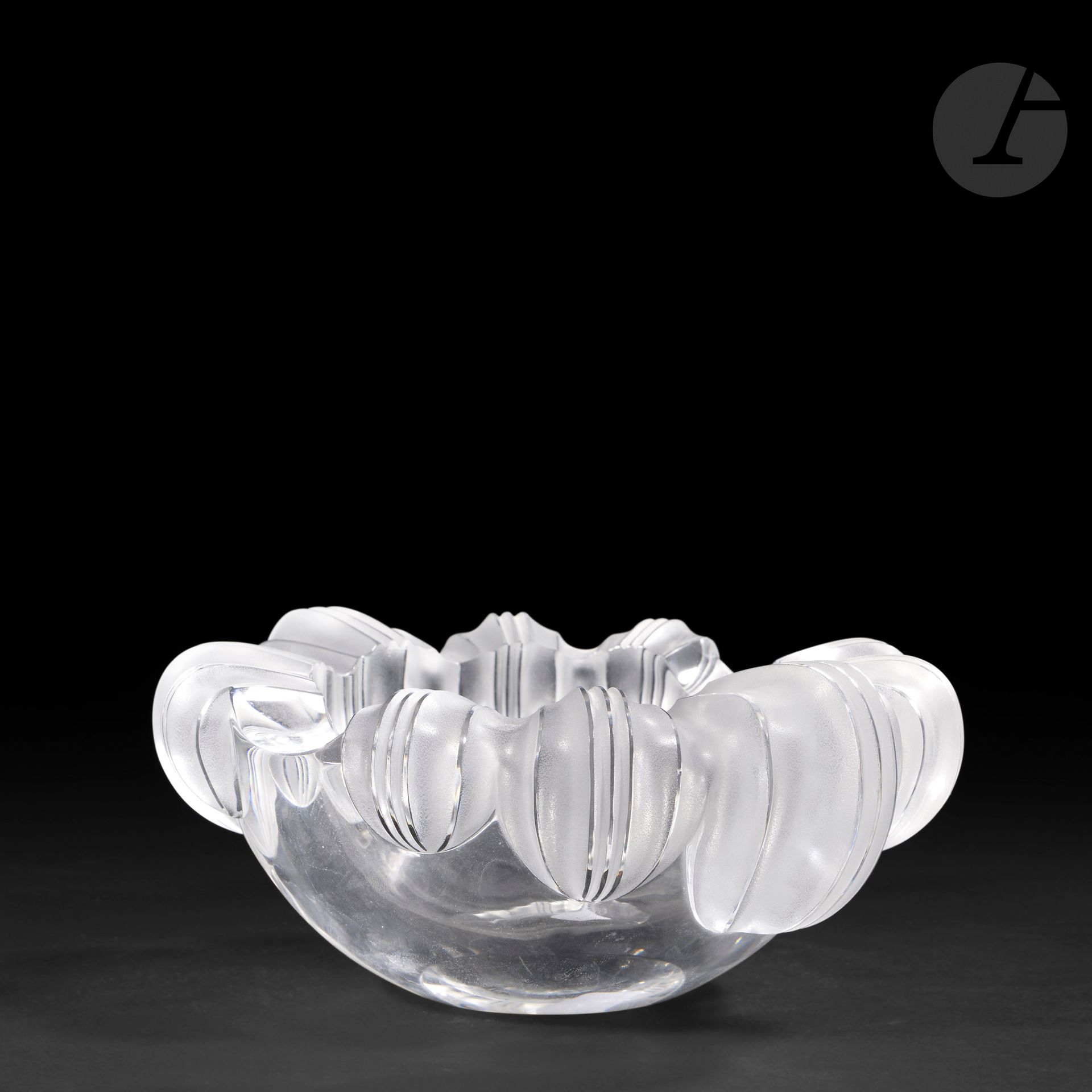 MARIE-CLAUDE LALIQUE (1935-2003) – MAISON LALIQUE
Athéna
Coupe creuse ovale au contour orné de protubérances rainurées.
Épreuve en cristal moulé-pressé et, en partie, satiné.
Égrenure sur une arête.
Signée LALIQUE ® France en lettres cursives, à la pointe sous la base.
Hauteur: 9,2 cm – Longueur: 22,5 cm – Largeur: 18,5 cm