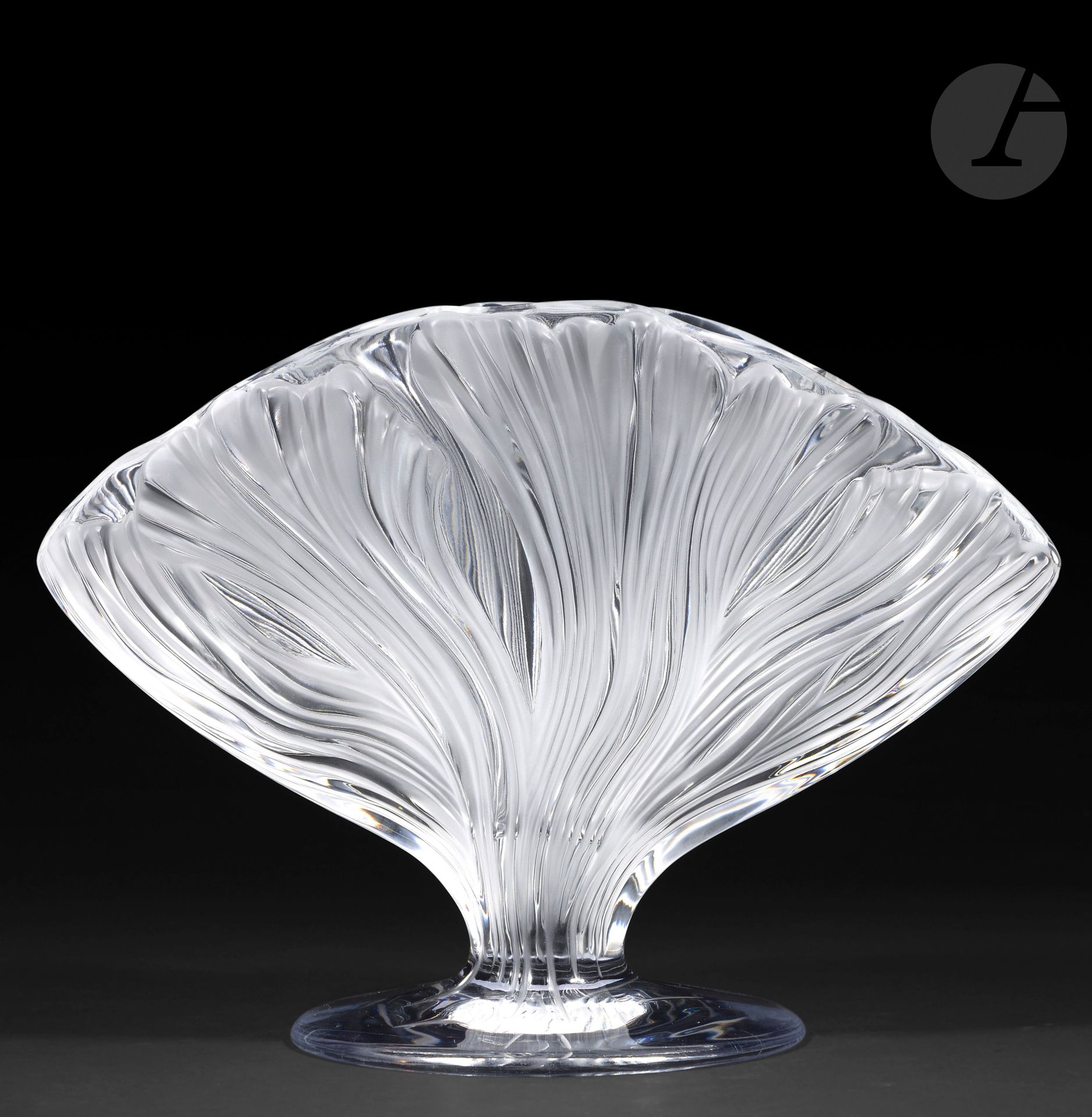 MARIE-CLAUDE LALIQUE (1935-2003) – MAISON LALIQUE
Ichor, le modèle conçu en [1993]
Vase en éventail à l’évocation d’une feuille de gingko, reposant sur piédouche.
Épreuve en cristal moulé-pressé et, en partie, satiné (Réf. Catalogue général Lalique 2012: 1247700).
Signé LALIQUE ® France en lettres cursives, à la pointe sous la base.
Hauteur: 24,5 cm – Longueur: 34 cm – Largeur: 17 cm