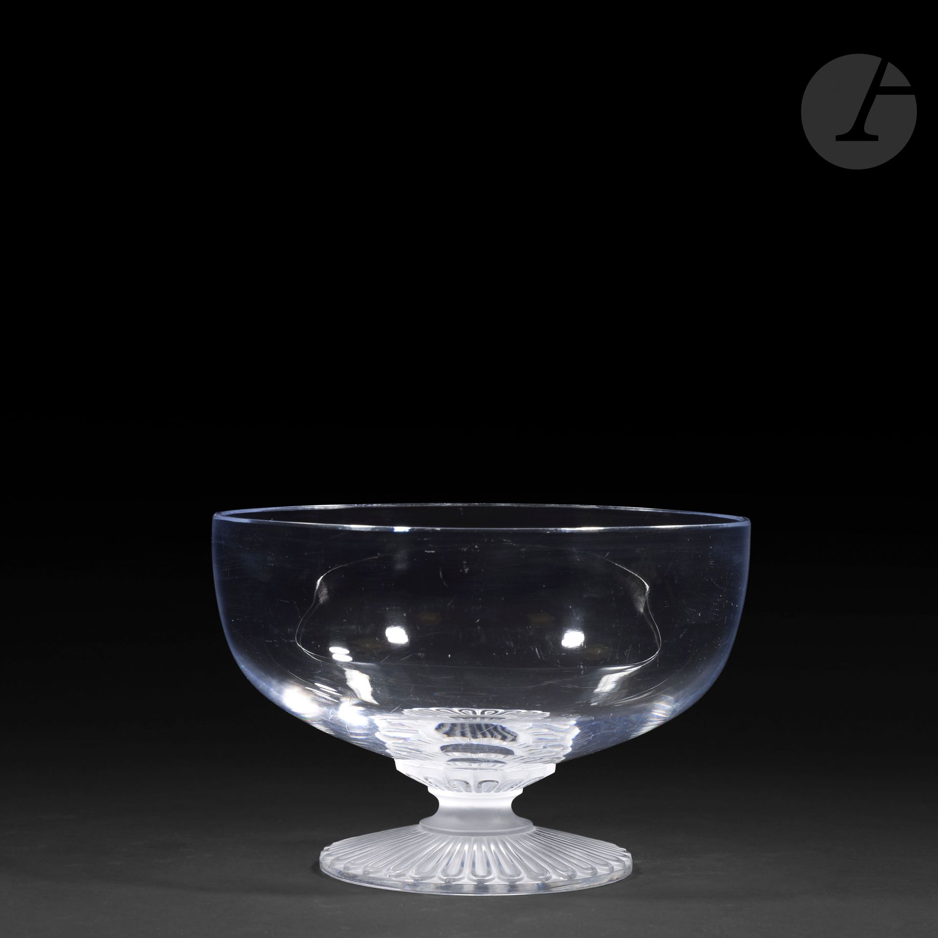 MARIE-CLAUDE LALIQUE (1935-2003) - MAISON LALIQUE
Elvire
Circular bowl on pedestal; the base decorated with gadroons. 
Proof in blown-molded and molded-pressed crystal, partly satin-finished. 
Minor chips around the edges. 
Signed LALIQUE France in cursive letters, at the point below the base.
Height: 14 cm - Diameter: 21.5 cm