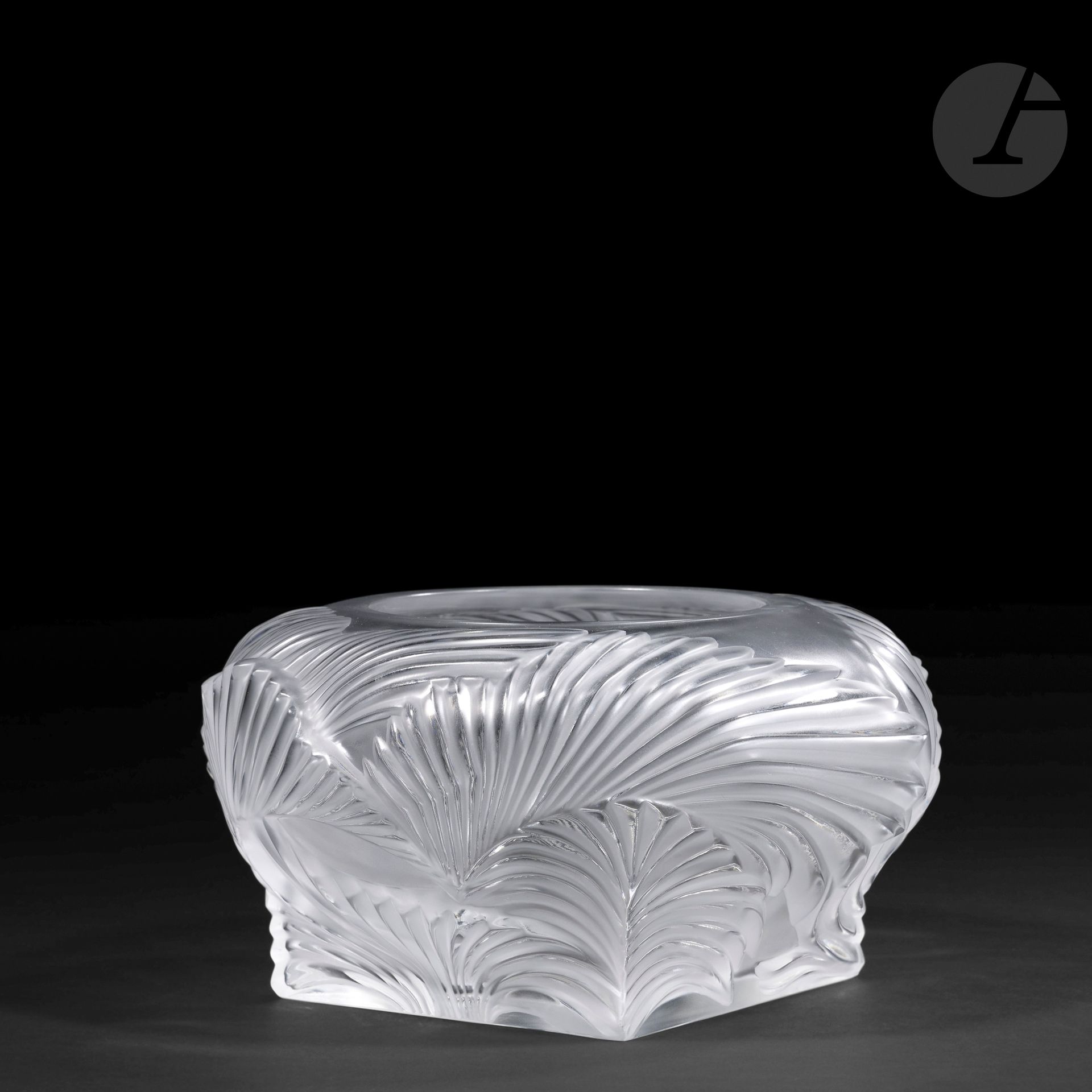 MARIE-CLAUDE LALIQUE (1935-2003) – MAISON LALIQUE
Hutan, le modèle conçu en [1994]
Vase pansu sur base carrée et à large col annulaire au décor en relief.
Épreuve en cristal moulé-pressé et satiné.
Petit défaut sur le pourtour du col.
Non signé.
Hauteur: 11,3 cm – Diamètre: 21 cm