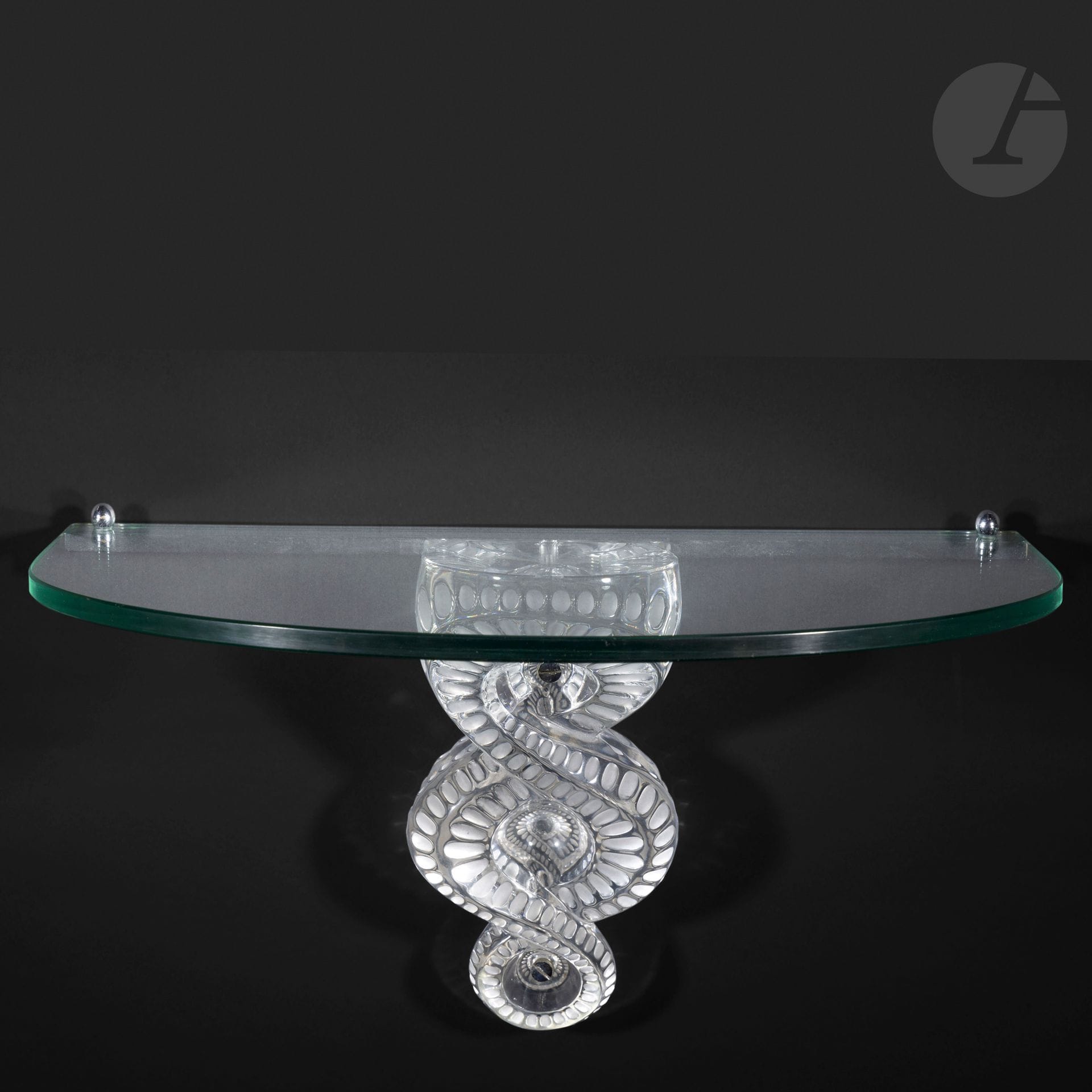 MARIE-CLAUDE LALIQUE (1935-2003) – MAISON LALIQUE
Séville, le modèle conçu en [1986]
Console d’applique.
Le motif central en cristal moulé-pressé et, en partie, satiné. 
Le plateau, à façade cintrée, en verre clair.
Complète de sa platine de fixation murale en métal chromé (Réf. Catalogue général Lalique 2012 : 1005500).
Signée LALIQUE ® France en lettres cursives, à la pointe, vers l’extrémité. 
Hauteur: 28 cm – Largeur: 50 cm – Profondeur: 30 cm