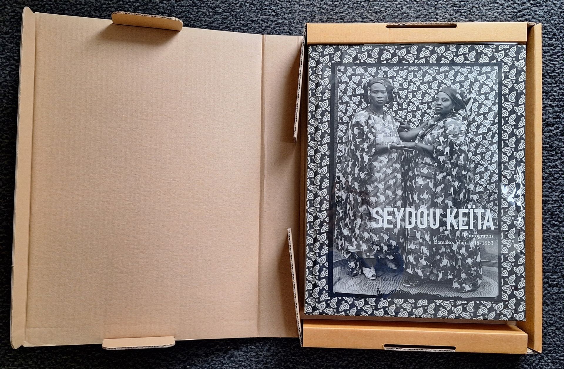 KEITA, SEYDOU (1923-2001)
Seydou Keïta Photographs
Bamako, Mali 1948-1963.
Steidldangin, 2011.
Grand in-4 (36 x 29 cm). Édition originale en anglais. Texte de Kathy Ryan et conversation avec André Magnin. 319 portraits photographiques de Seydou Keïta réalisés par le photographe dans son studio de Bamako. Très belle impression en tritone. Couverture en tissu pictural avec image photographique apposée sur le panneau avant, sous jaquette transparente. Bien complet du carton d'expédition titré de l'éditeur. L'ensemble à l'état de neuf. Une magnifique réussite éditoriale.