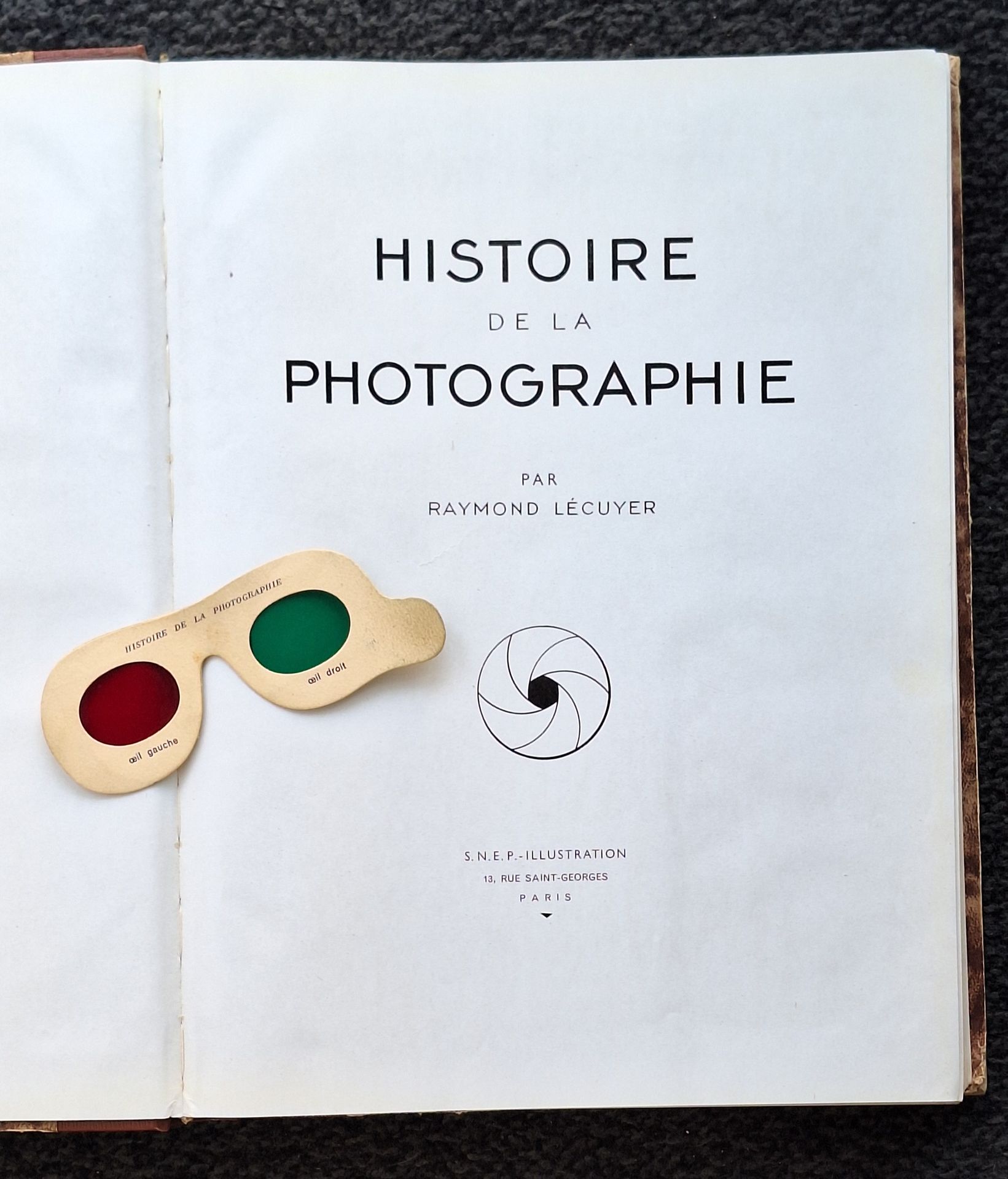 LECUYER, RAYMOND (1879-1950)
Histoire de la photographie.
Baschet et Cie, Paris, 1945.
In-folio (38,5 x 29 cm). Édition originale. 455 pp. 19 planches en couleurs et 55 planches monochromes hors texte ainsi que de très nombreuses illustrations in-texte. Exemplaire complet de sa paire de lorgnons bicolores. Reliure en demi-percaline.