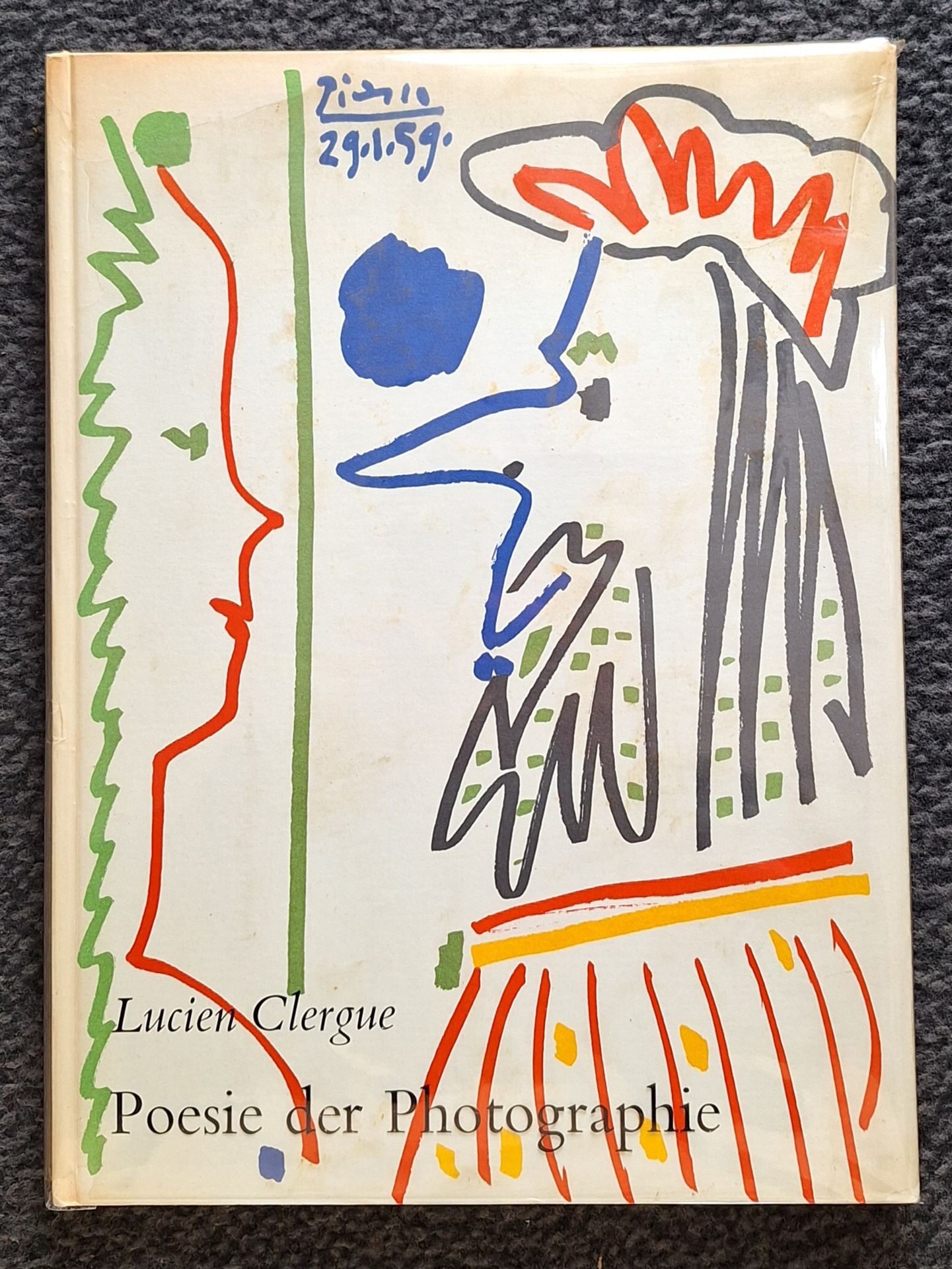 CLERGUE, LUCIEN (1934-2014) [Signed]
Poesie der Photographie.
Verlag M. Dumont Schauberg, Köln, 1960.
In-4 (33 x 24 cm). Édition originale en allemand, dédicacée et signée par Lucien Clergue au photographe lyonnais René Basset. Cartonnage d'éditeur et frontispice illustrés de dessins de Picasso. Introduction de Jean Cocteau. Un dessin de Jean Cocteau reproduit en fac-similé. Cartonnage recouvert de la fragile jaquette transparente titrée en noir de l'éditeur (déchirures et manques à cette jaquette transparente, n'affectant pas le titre).