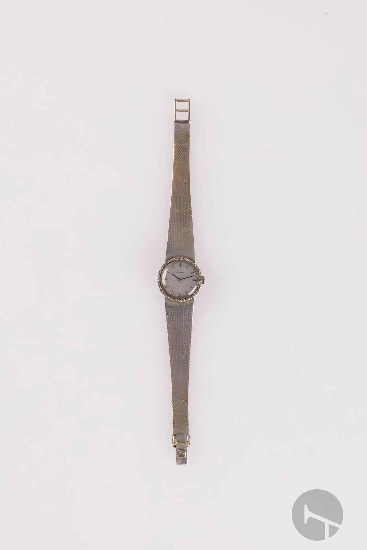 CERTINA
ANNÉES 70
Montre bracelet de dame en or gris 18K (750) et diamants.
Boîtier: rond, lunette piquée de petits diamants ronds taille 8/8.
Cadran: argenté, index bâton appliqués.
Mouvement: mécanique.
Bracelet: intégré en or gris satiné, boucle simple, signée.
Signée et numérotée 850643.
Diam.: 22mm 
Poids brut: 40,84g
Longueur: 17,5cm.
Avec: boîte Certina