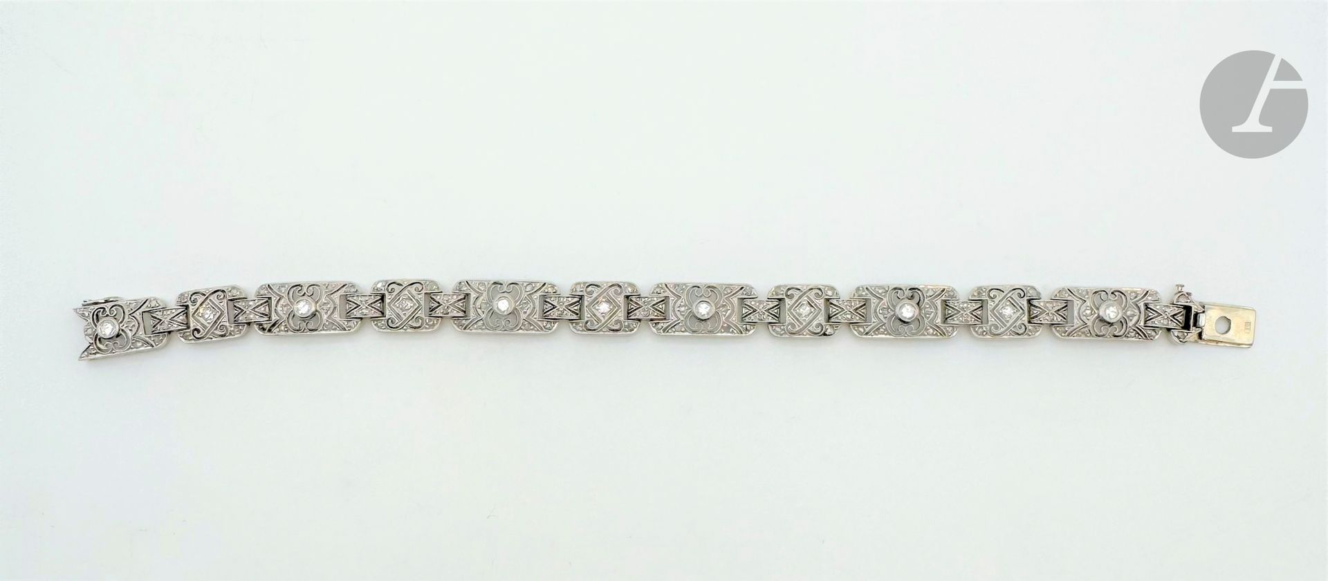 Bracelet en or gris 18K (750) et platine, articulé de maillons rectangulaires repercés de motifs géométriques piqués de diamants taillés en roses et 16/16. Longueur : 17 cm environ. Poids brut : 16,6 g (égrisures, chocs)
